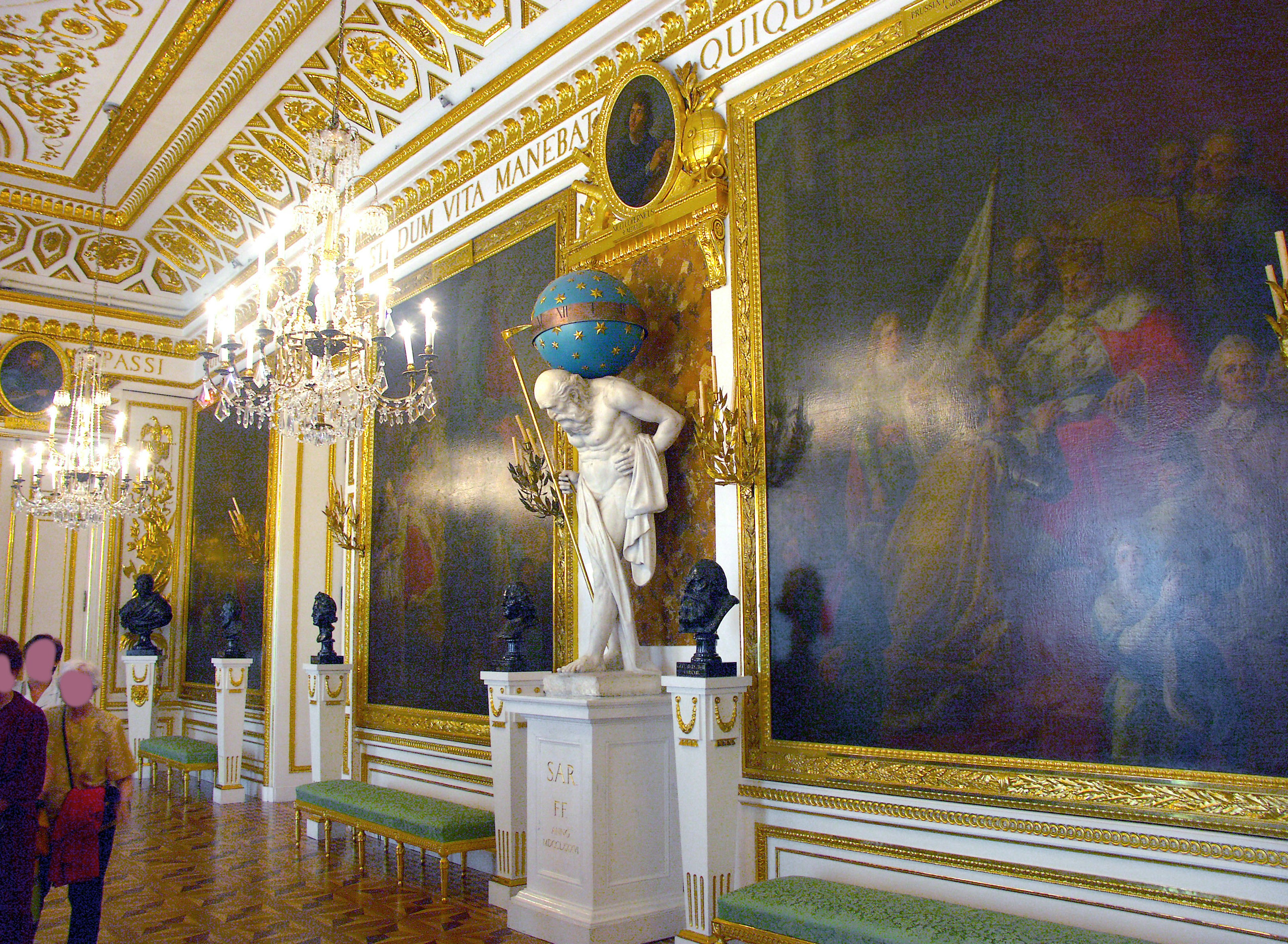 Chambre avec une statue et de grandes peintures ornées de décorations dorées