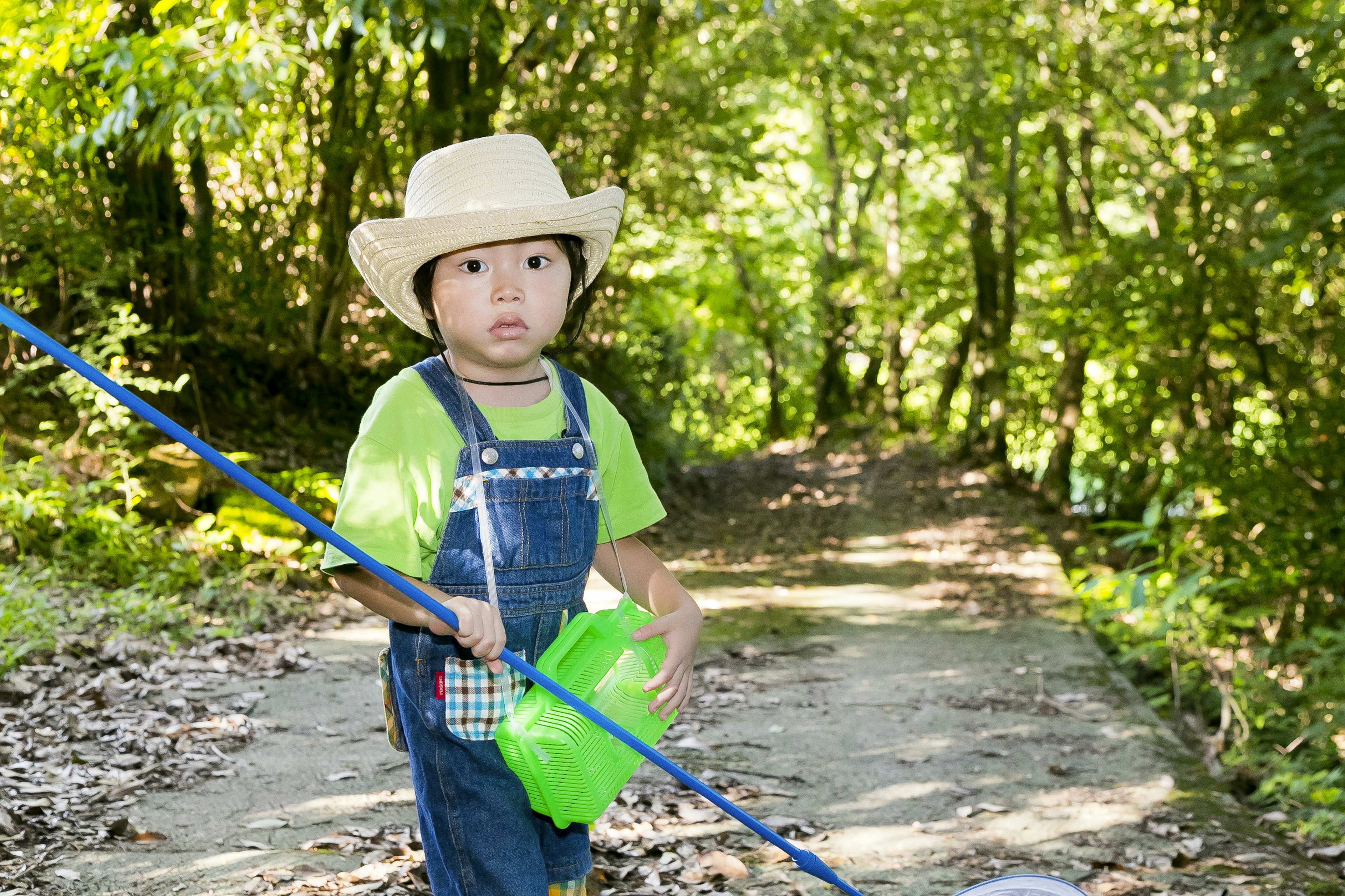 Enfant portant un chapeau de cowboy marchant dans une forêt verte