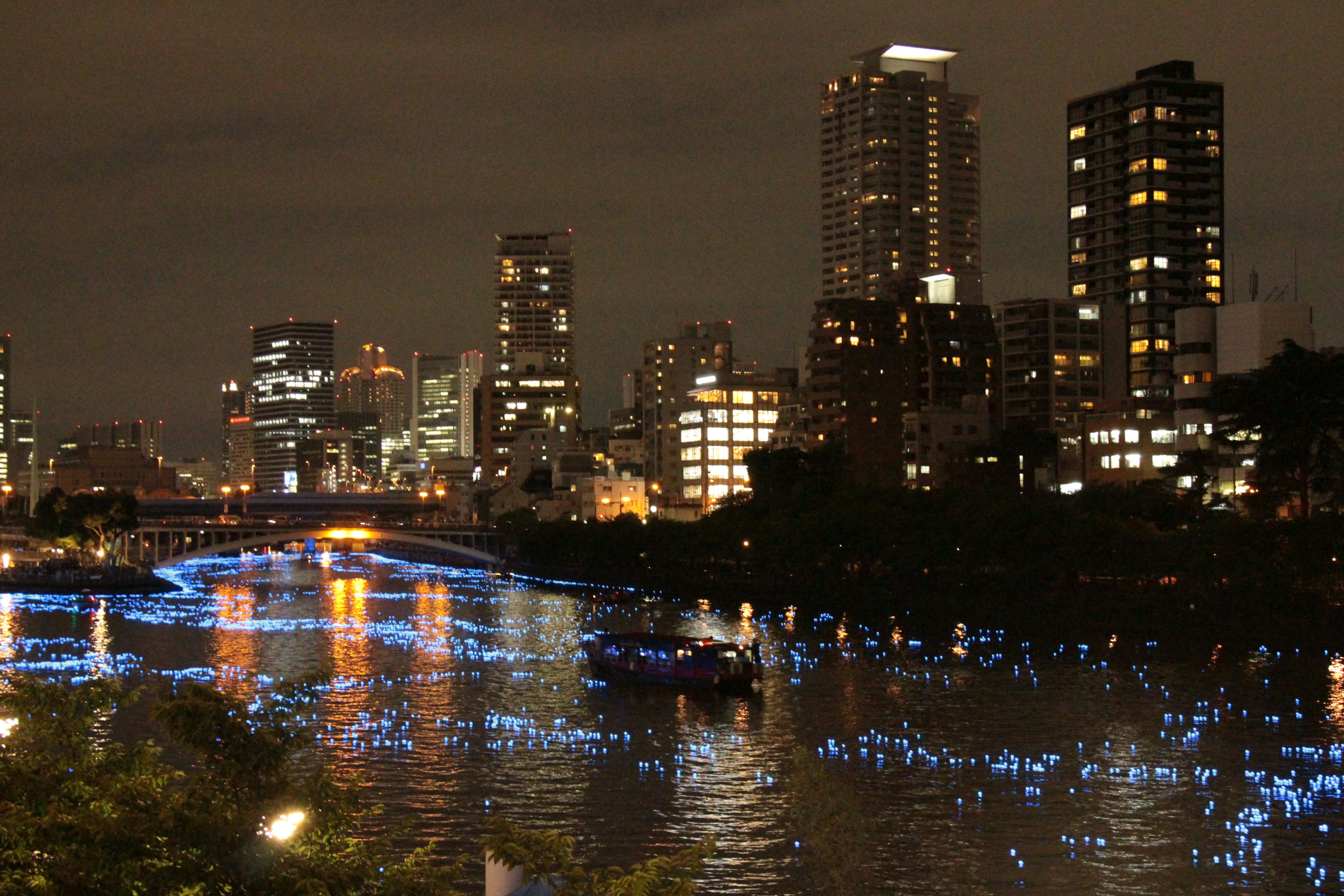 夜の都市景観と青いライトが映る川