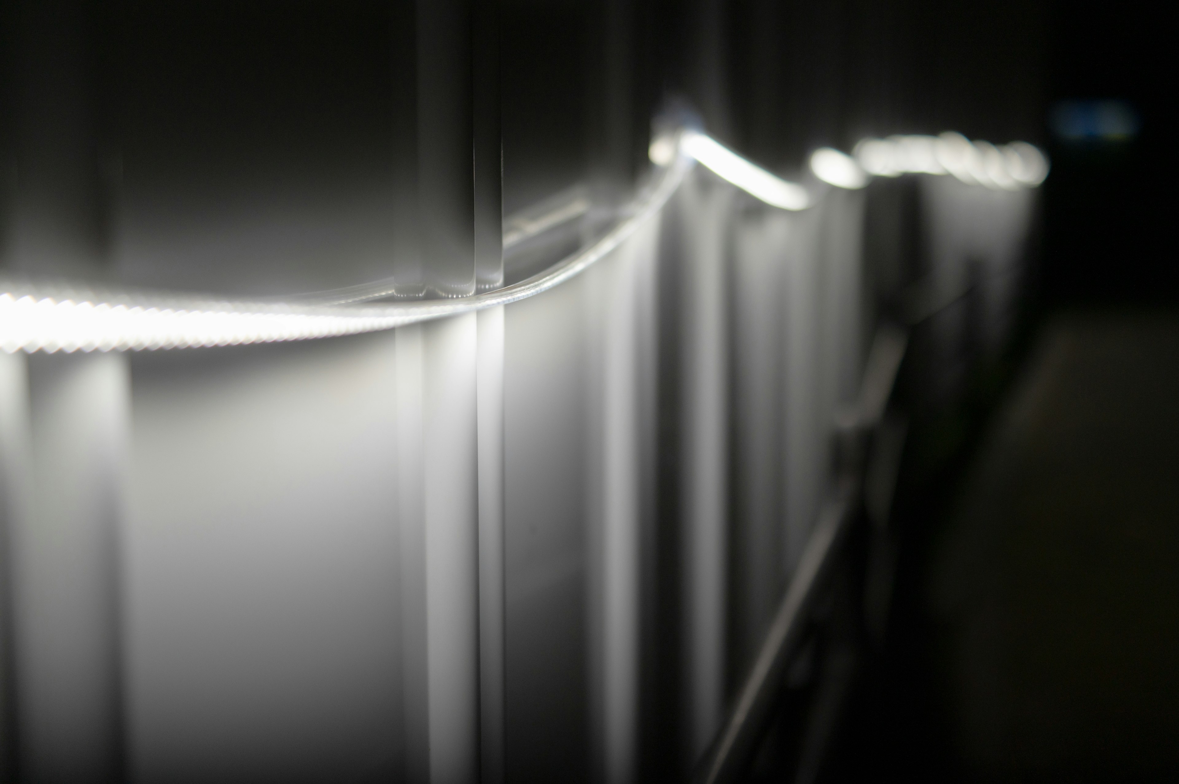 A line of white light extending along a dark wall