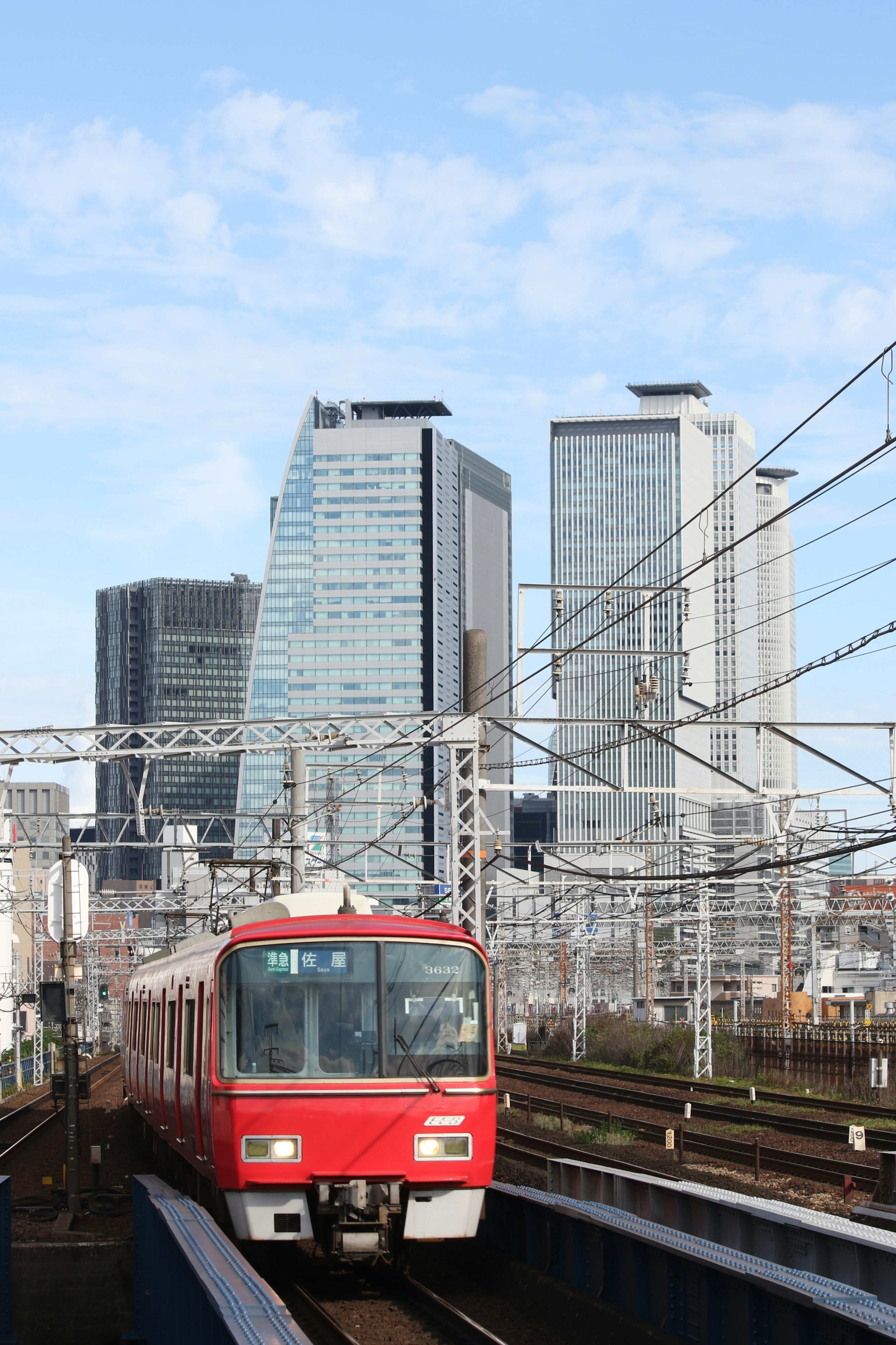 Train rouge circulant entre des bâtiments hauts