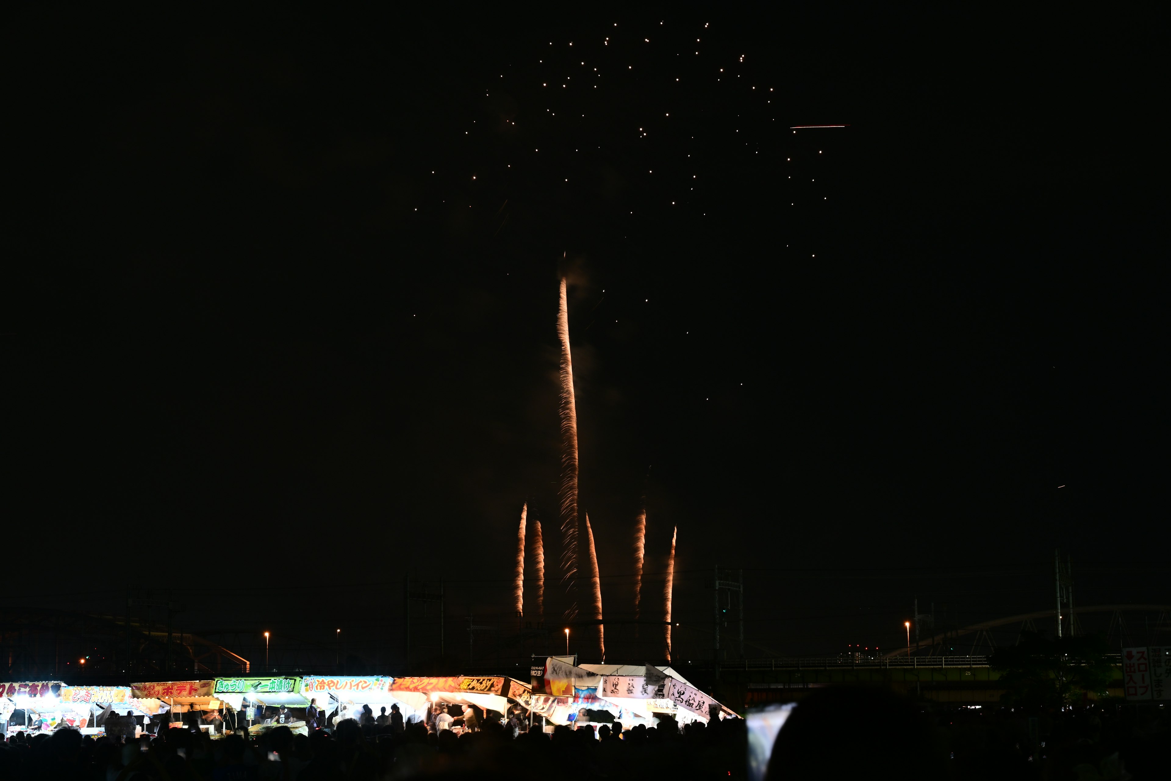 Fireworks lighting up the night sky above bright stalls