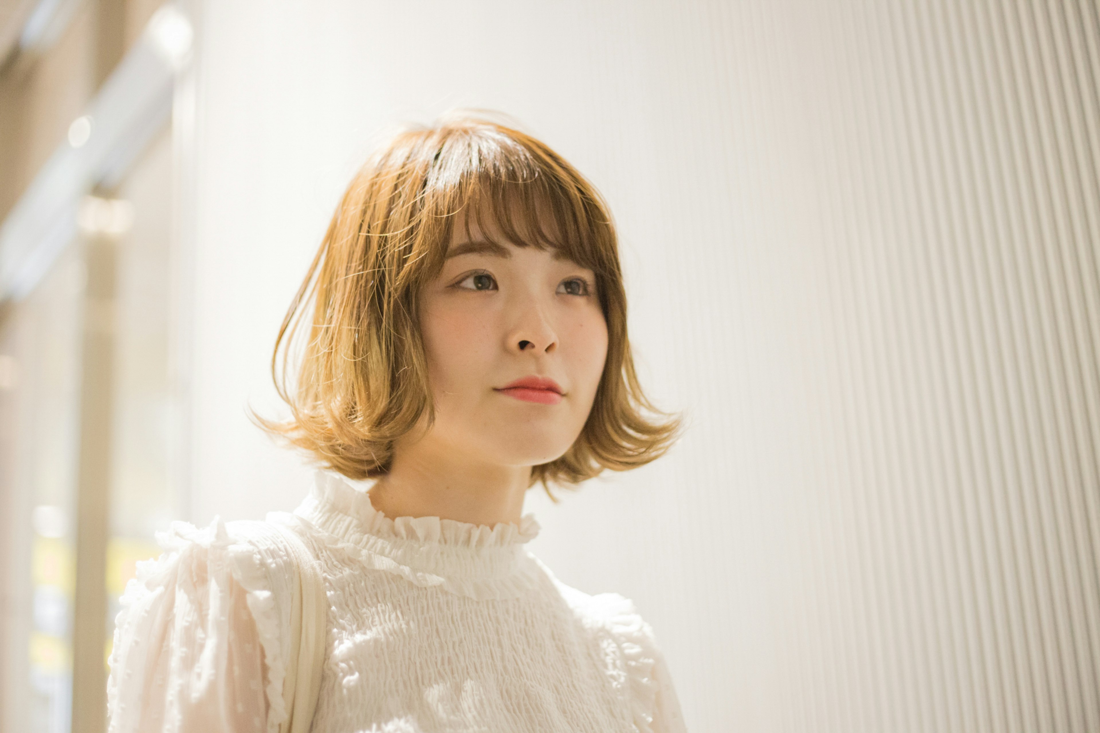 Young woman wearing a white outfit with a light background