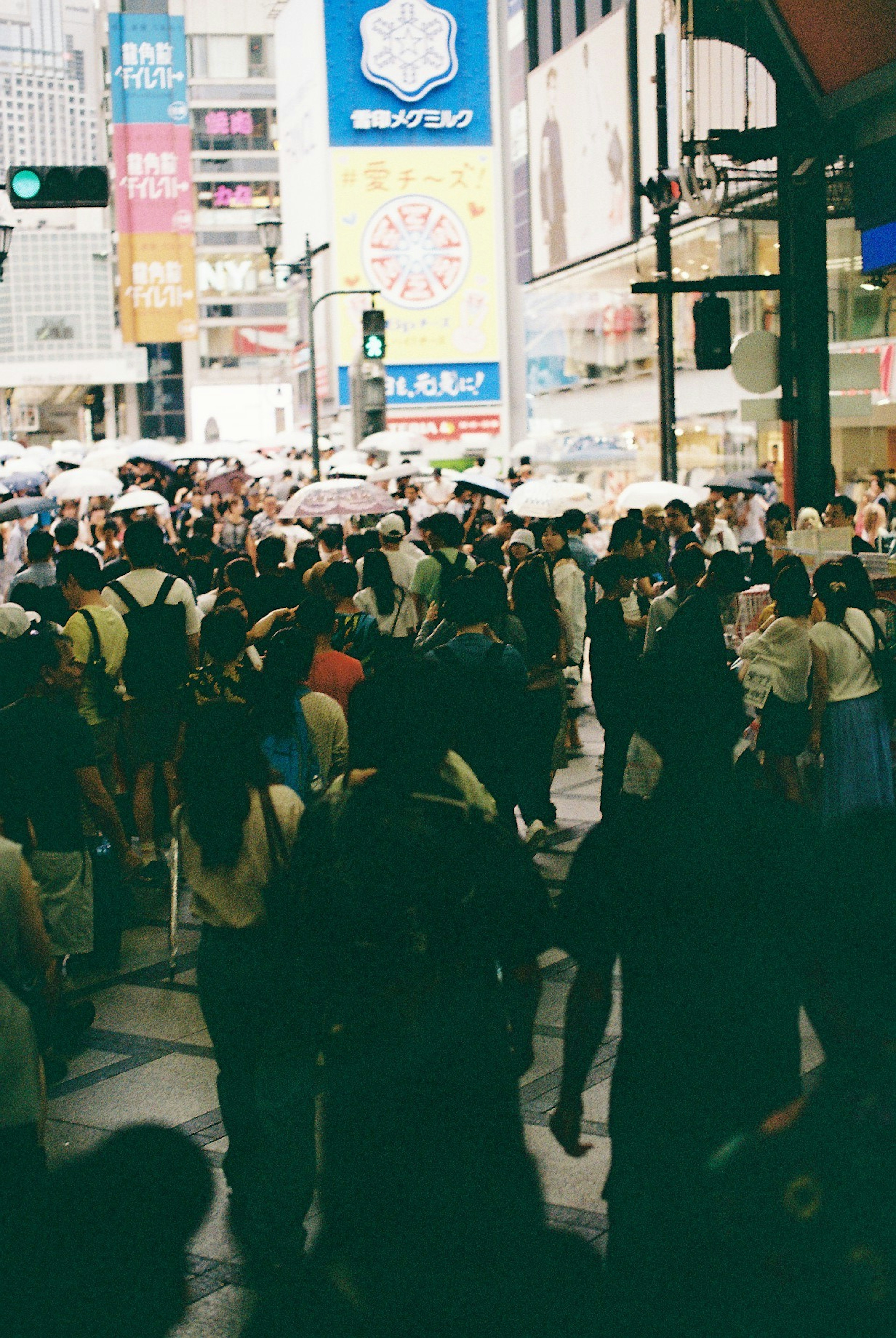 Crowd of people walking in a busy street with colorful banners