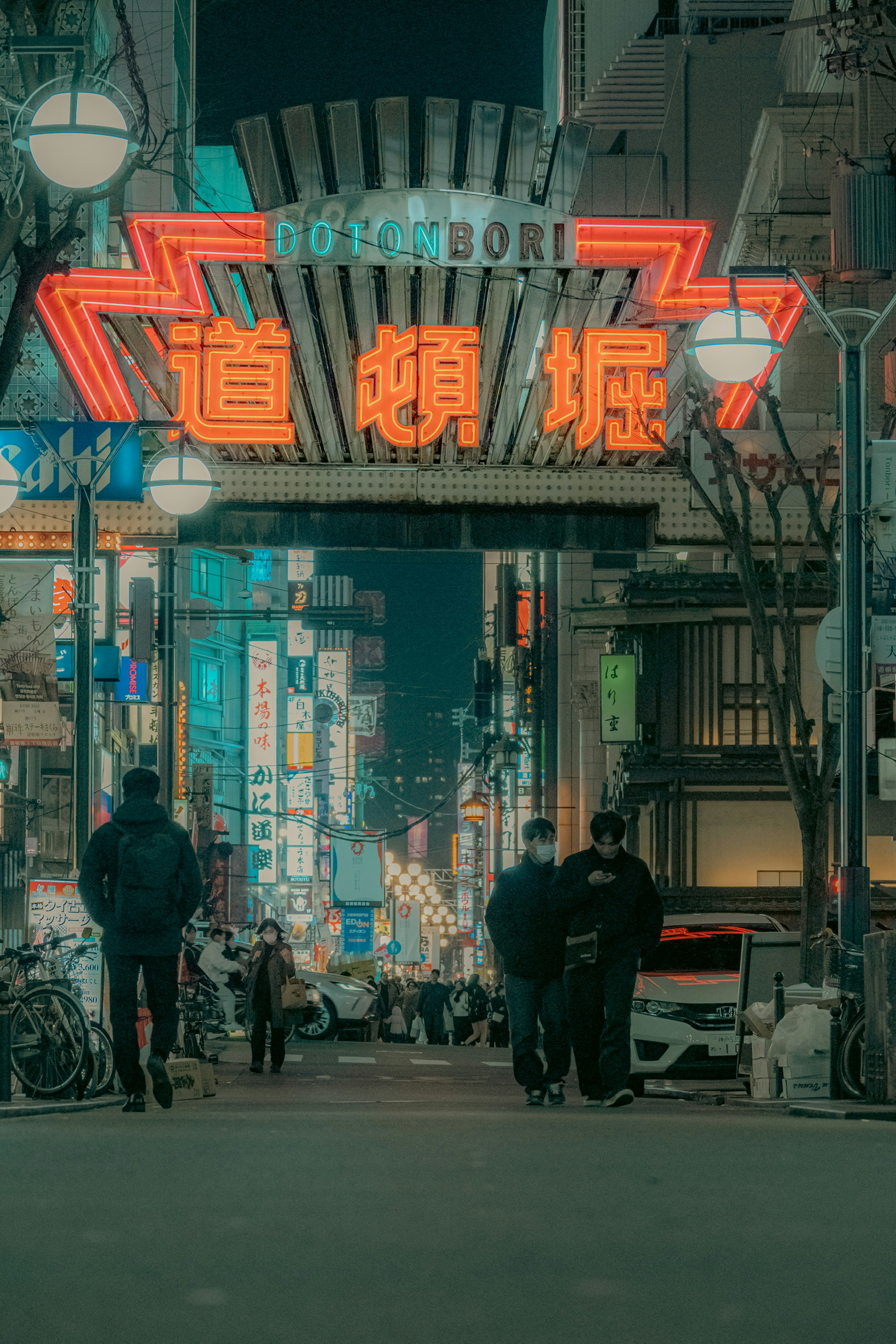 Illuminated Dotonbori entrance with vibrant neon signs in a nighttime setting