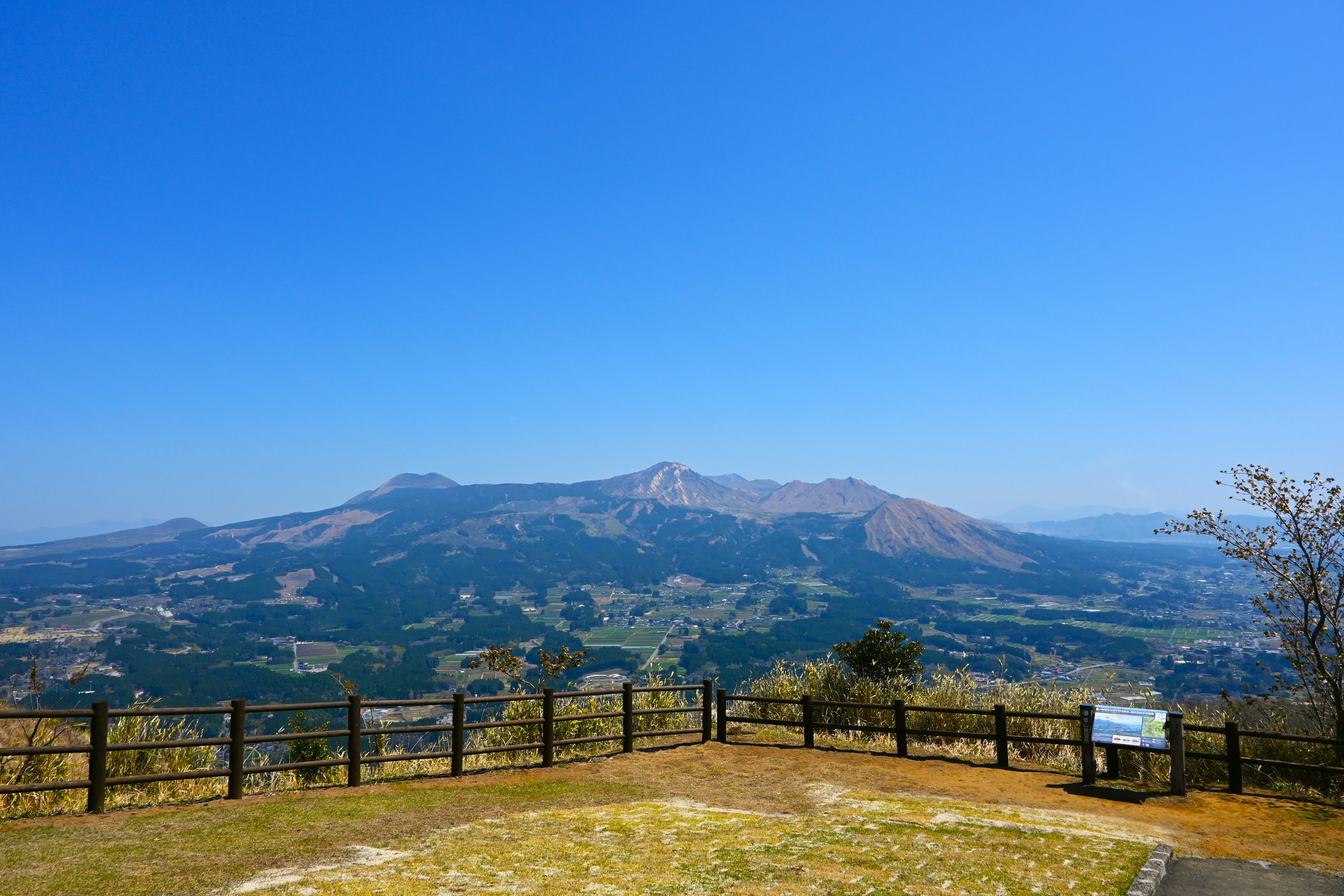 View from an observation deck featuring mountains and clear blue sky