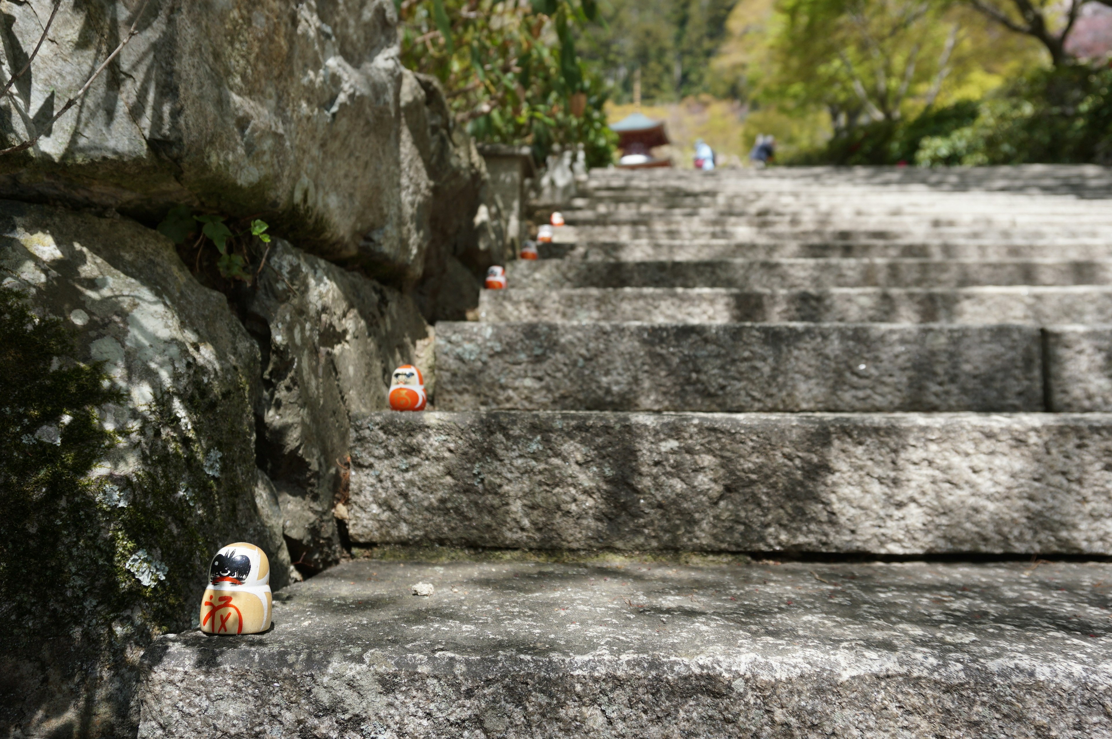 Pequeñas figuritas de cerámica alineadas en una escalera de piedra