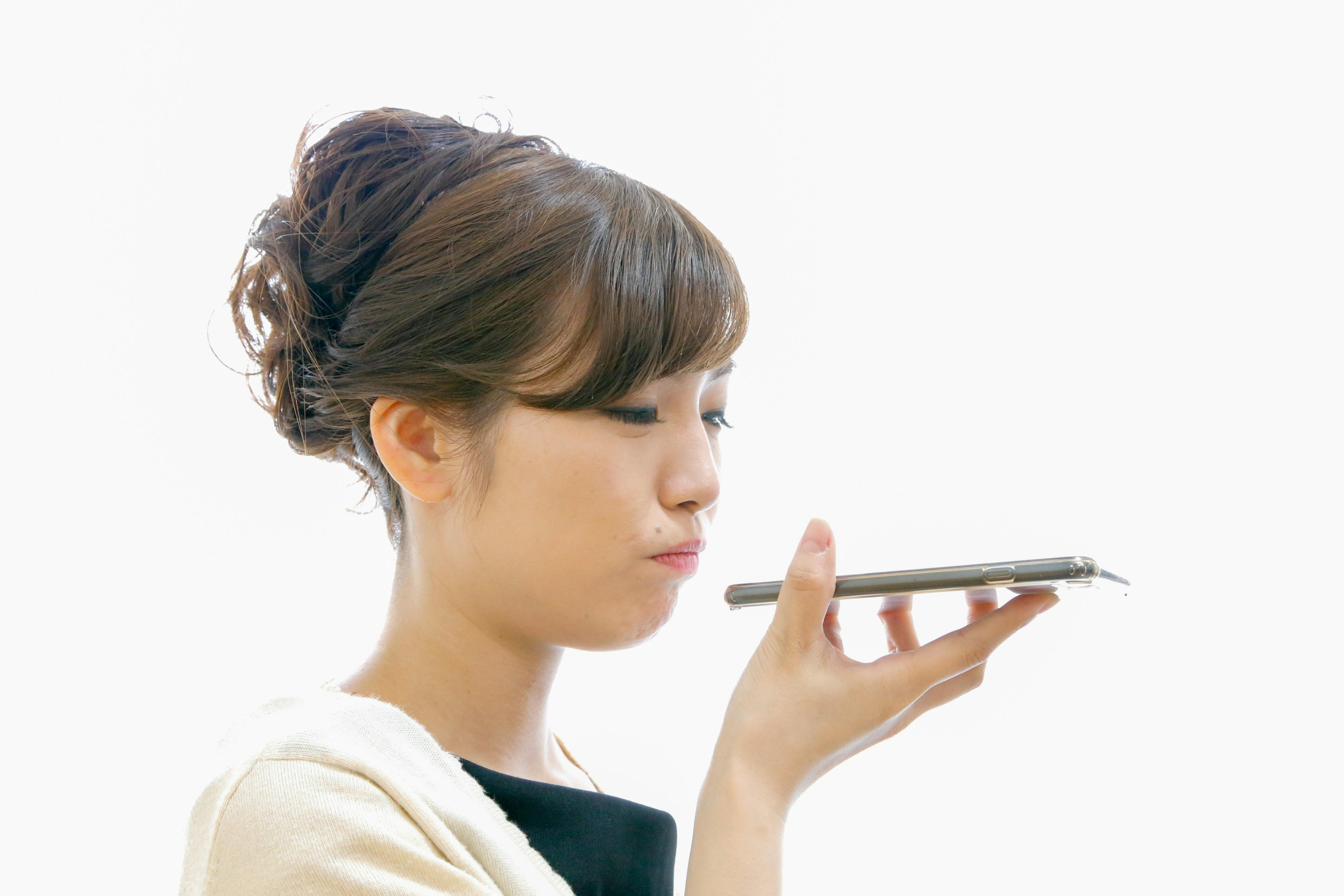 A woman holding a smartphone speaking into it