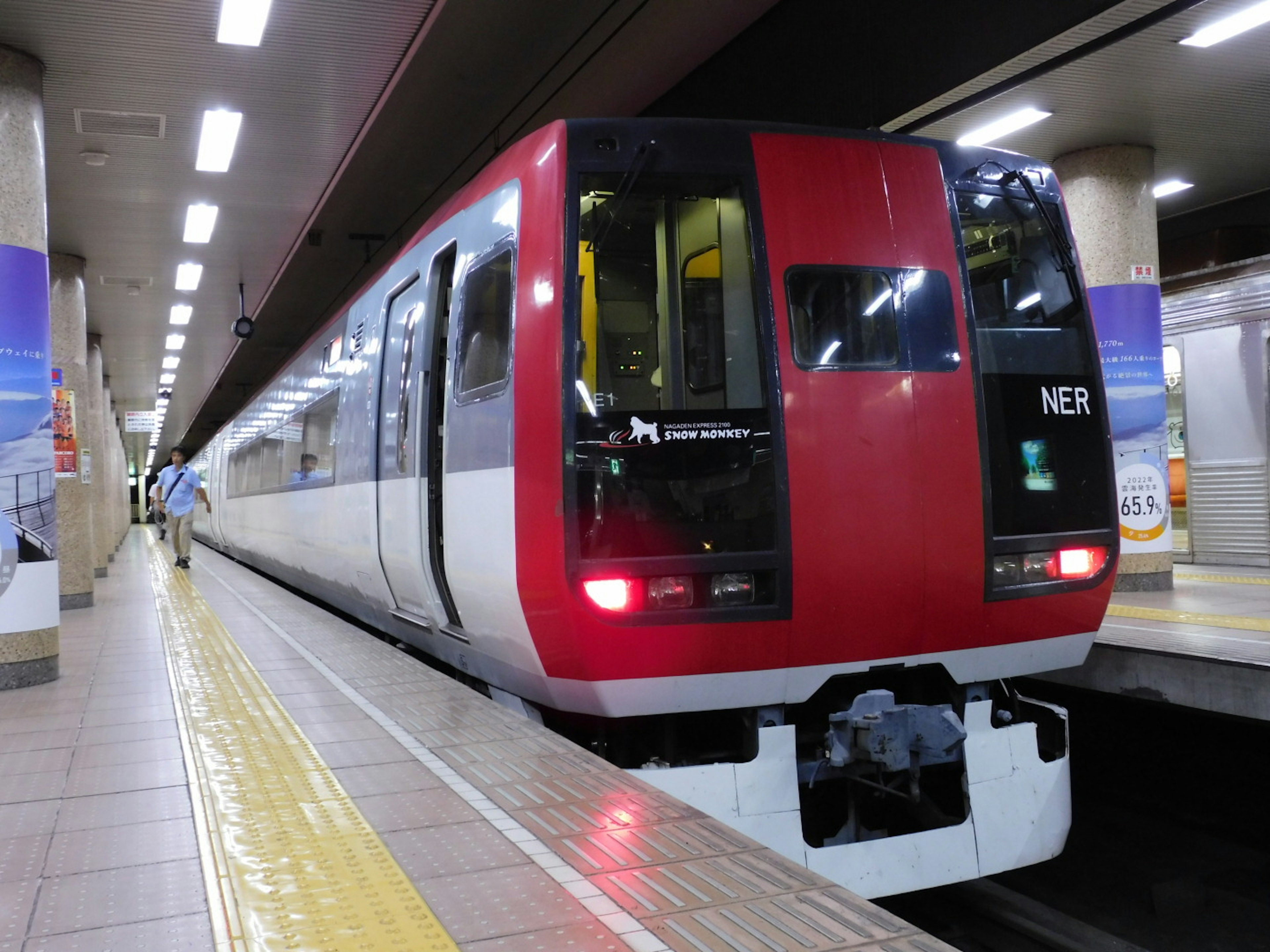 Roter und weißer Zug hält an der Station