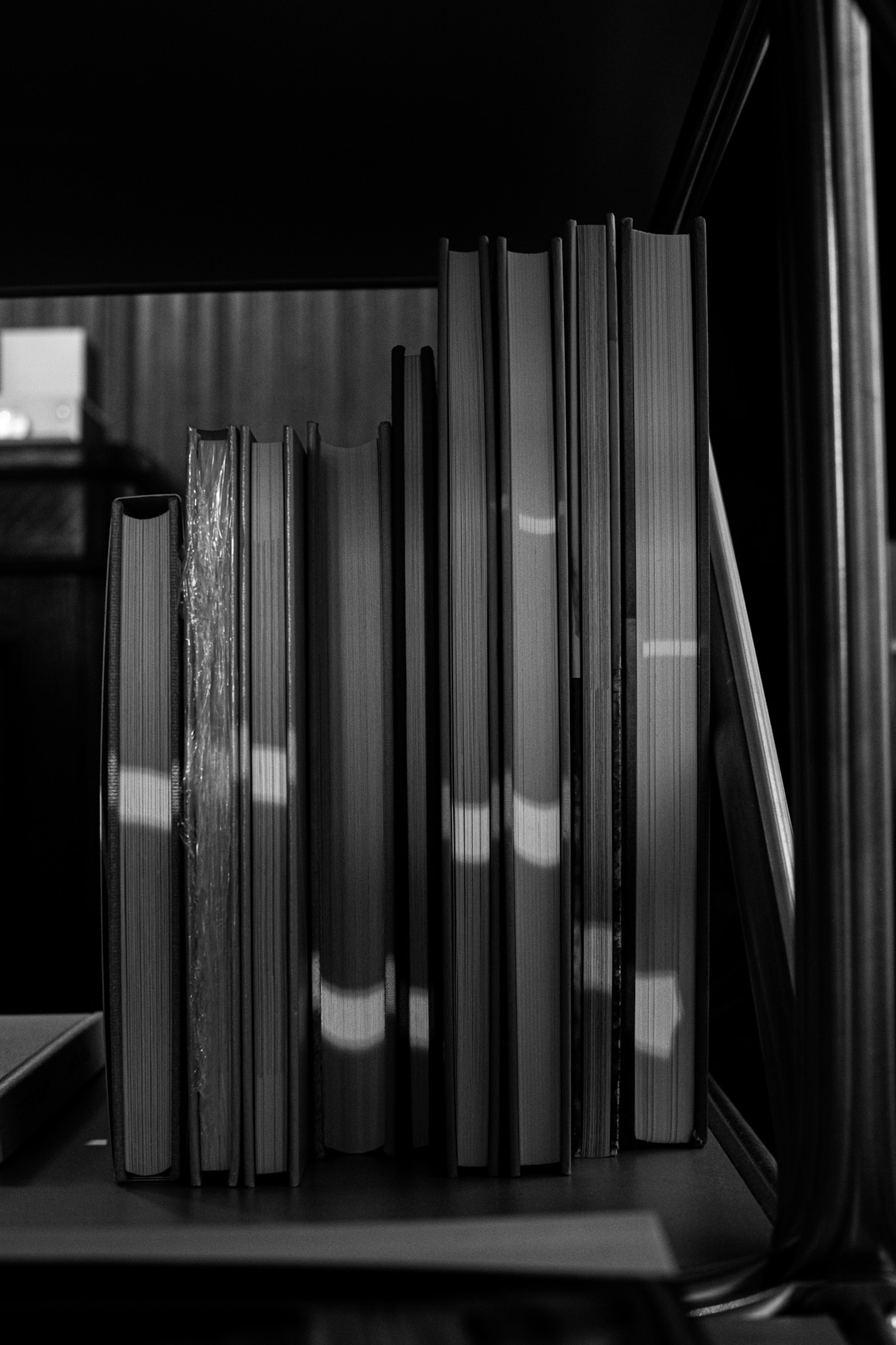 A section of a bookshelf with black and white books arranged neatly