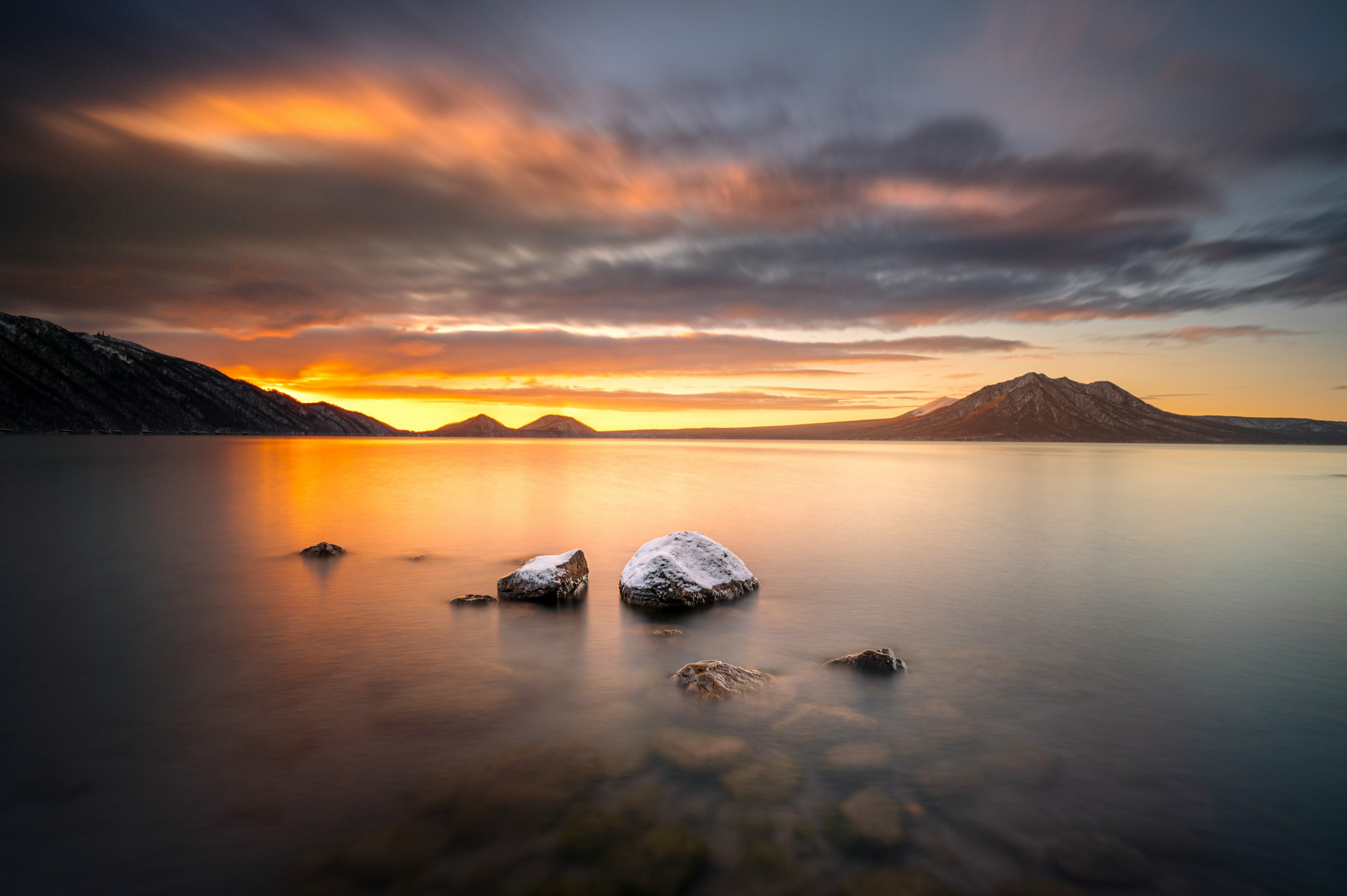 湖と山の美しい夕日風景 水面に映るオレンジと紫の色合い