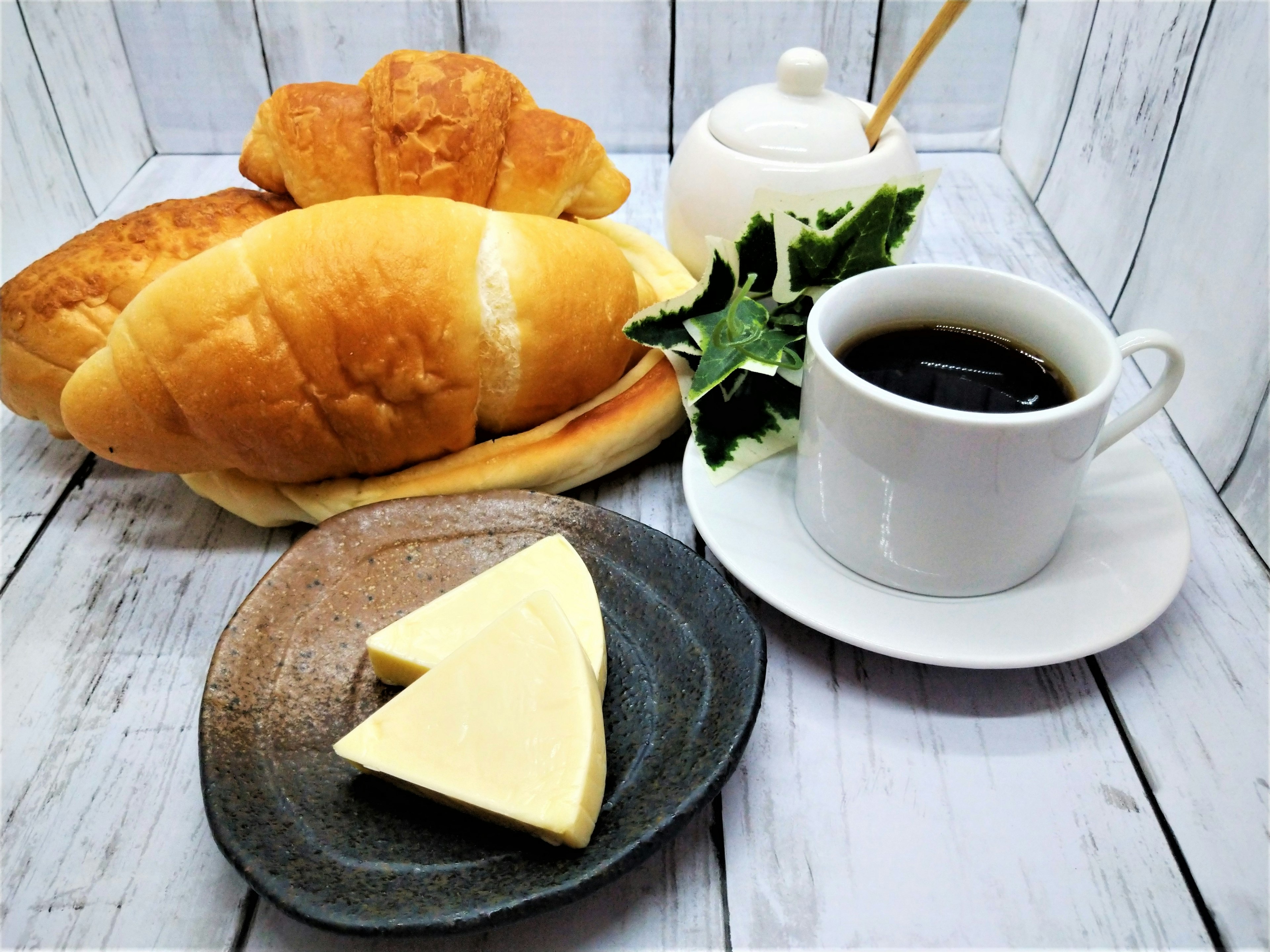 Petit-déjeuner avec plusieurs pains et café beurre et feuilles de salade inclus