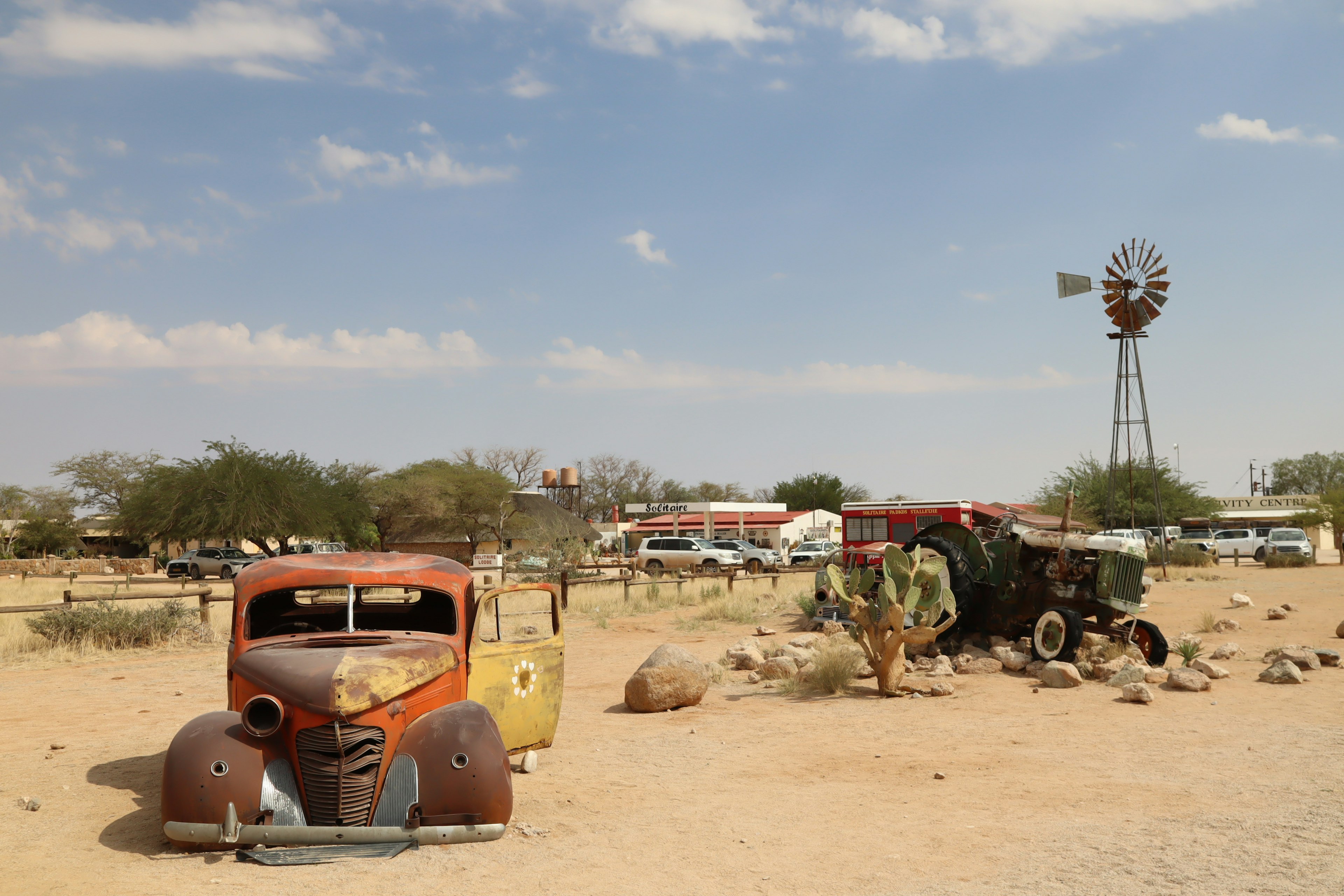 Rusty vintage truck and windmill in a dry landscape