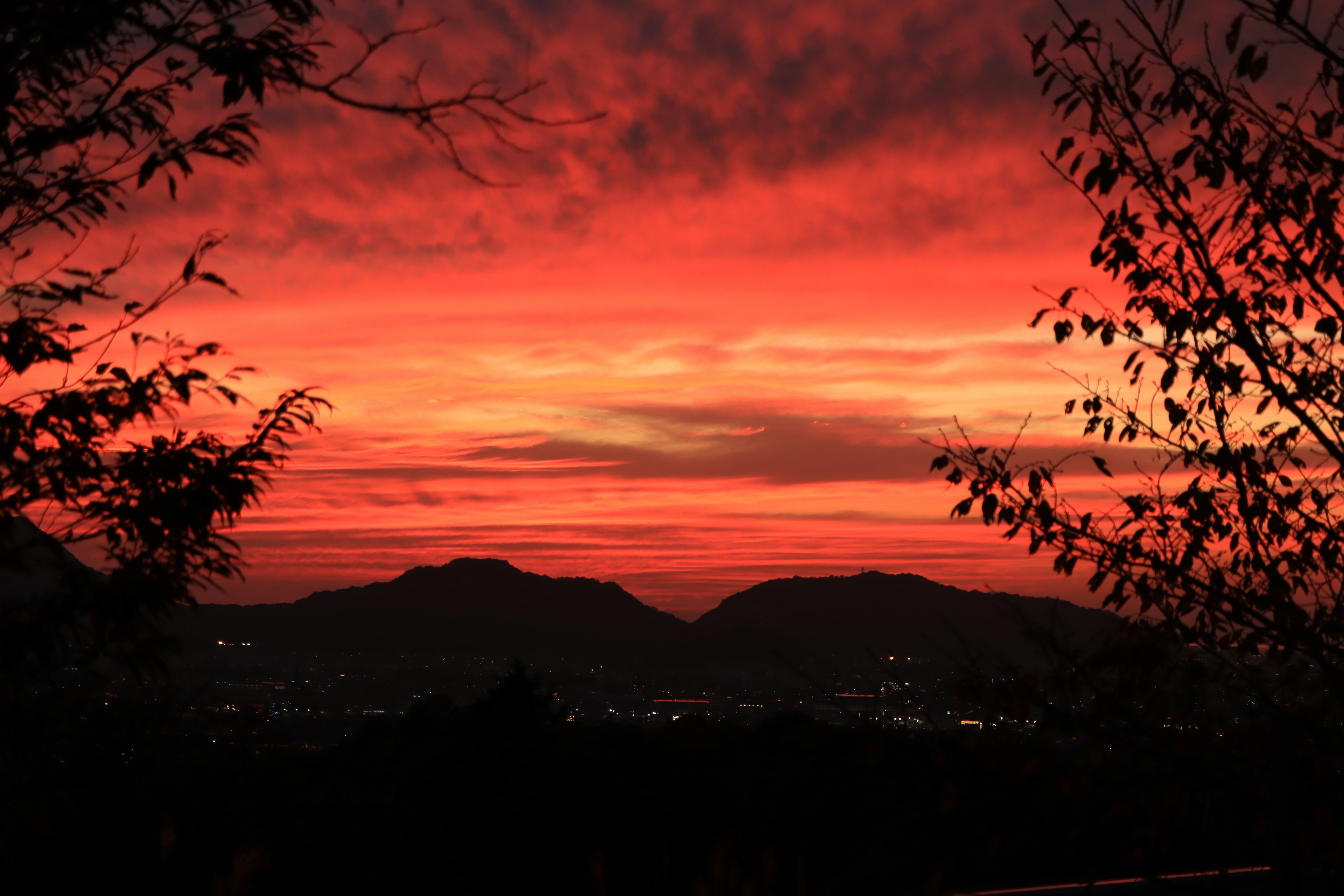 Stupendo cielo al tramonto rosso con montagne in silhouette