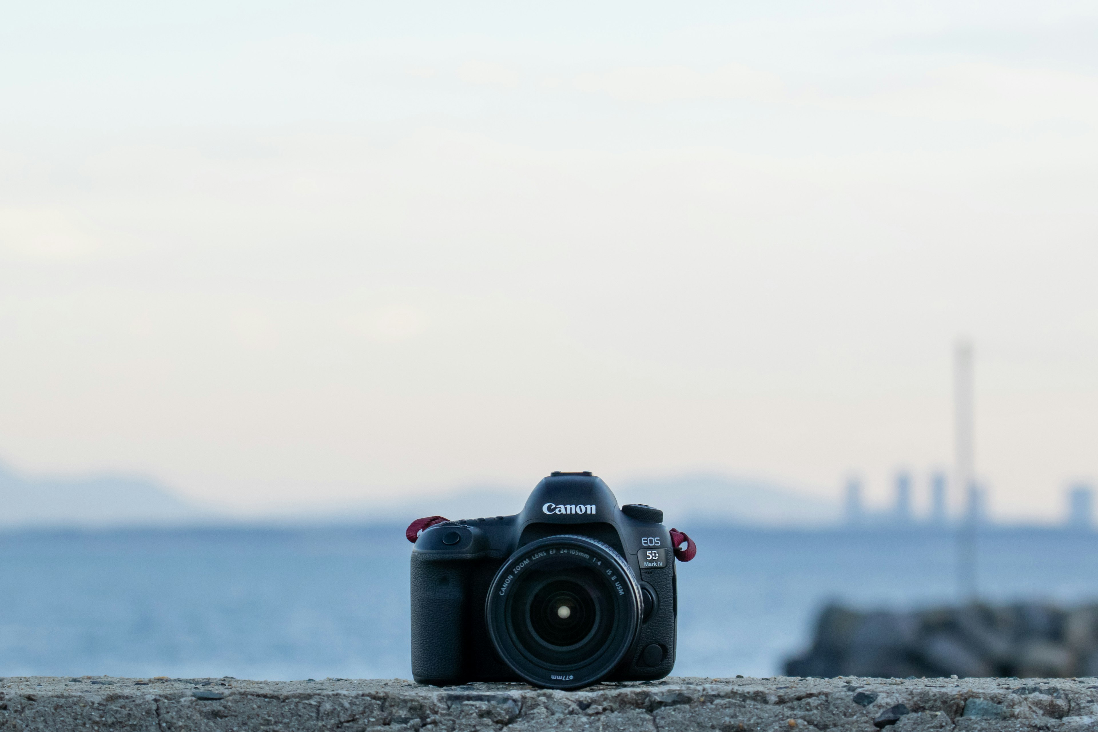 海の前に置かれたCanonのカメラと背景の空