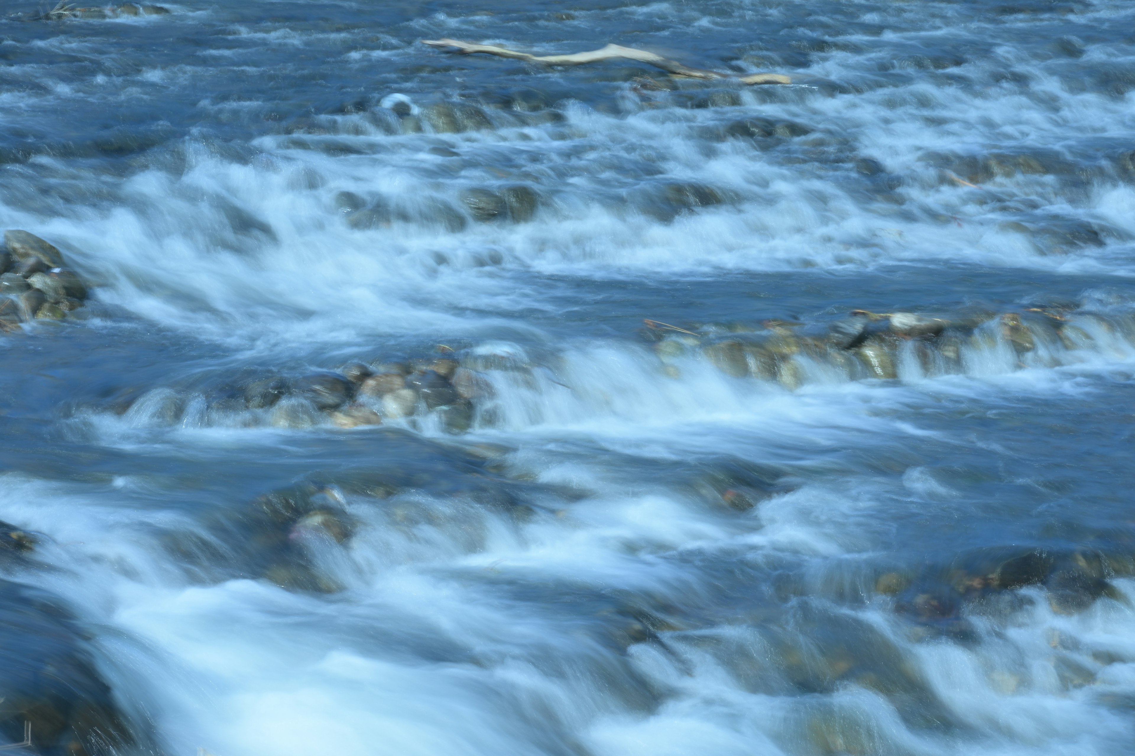 流れる水の美しい風景 岩が見える青い川の水の流れ