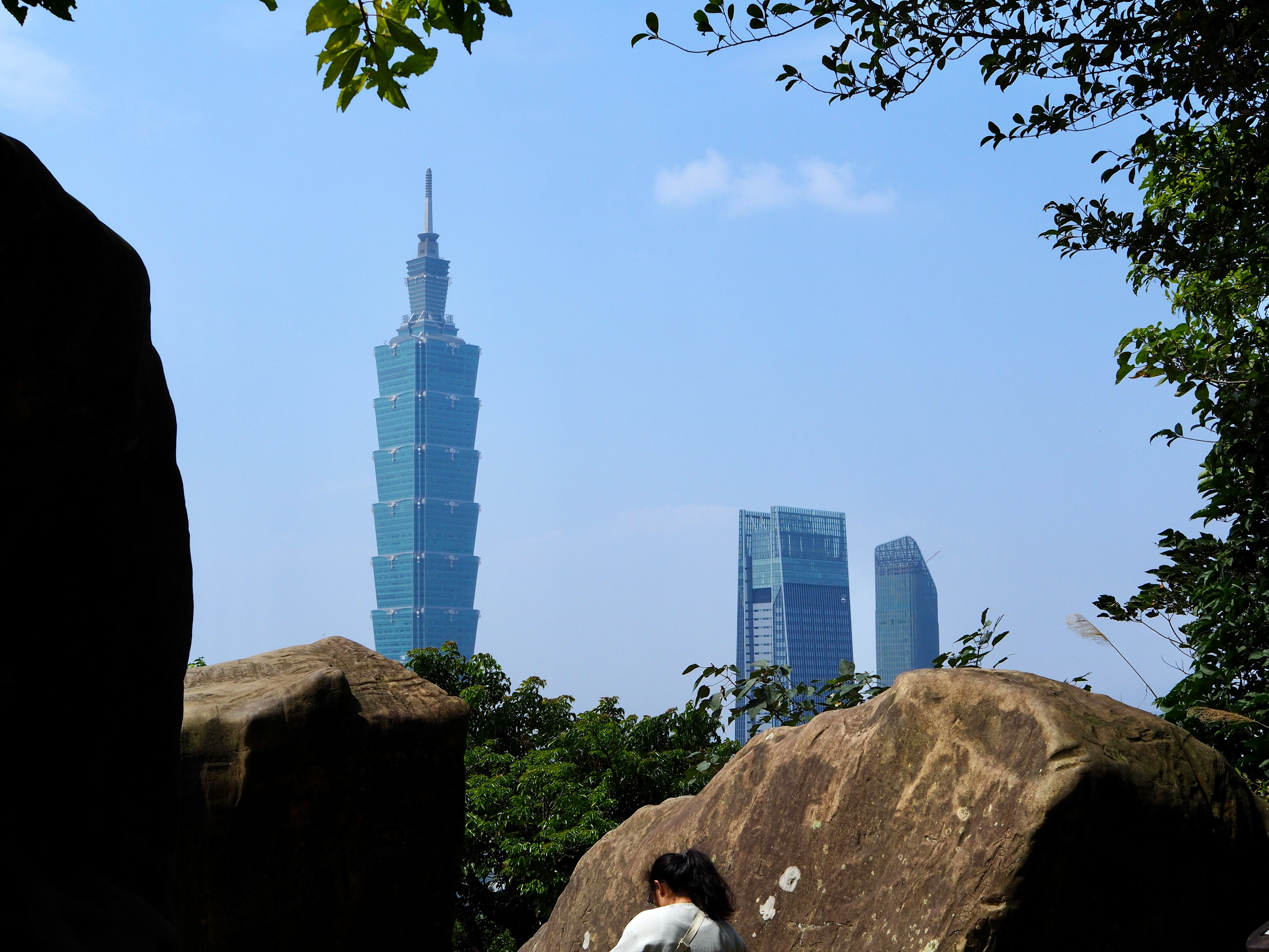 Cảnh đẹp của Taipei 101 với cây cối xanh tươi và đá