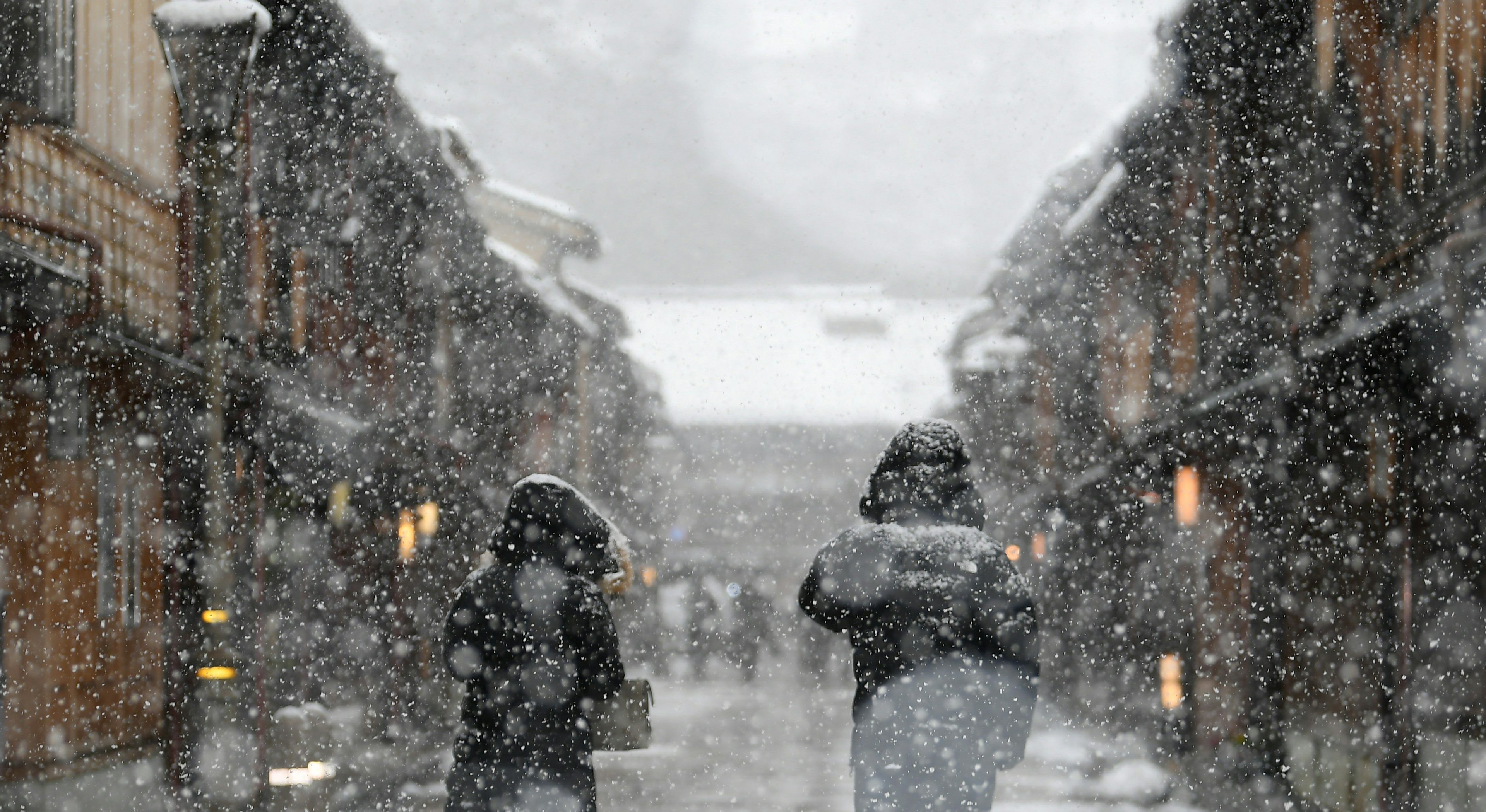 Persone che camminano nella neve in una strada storica