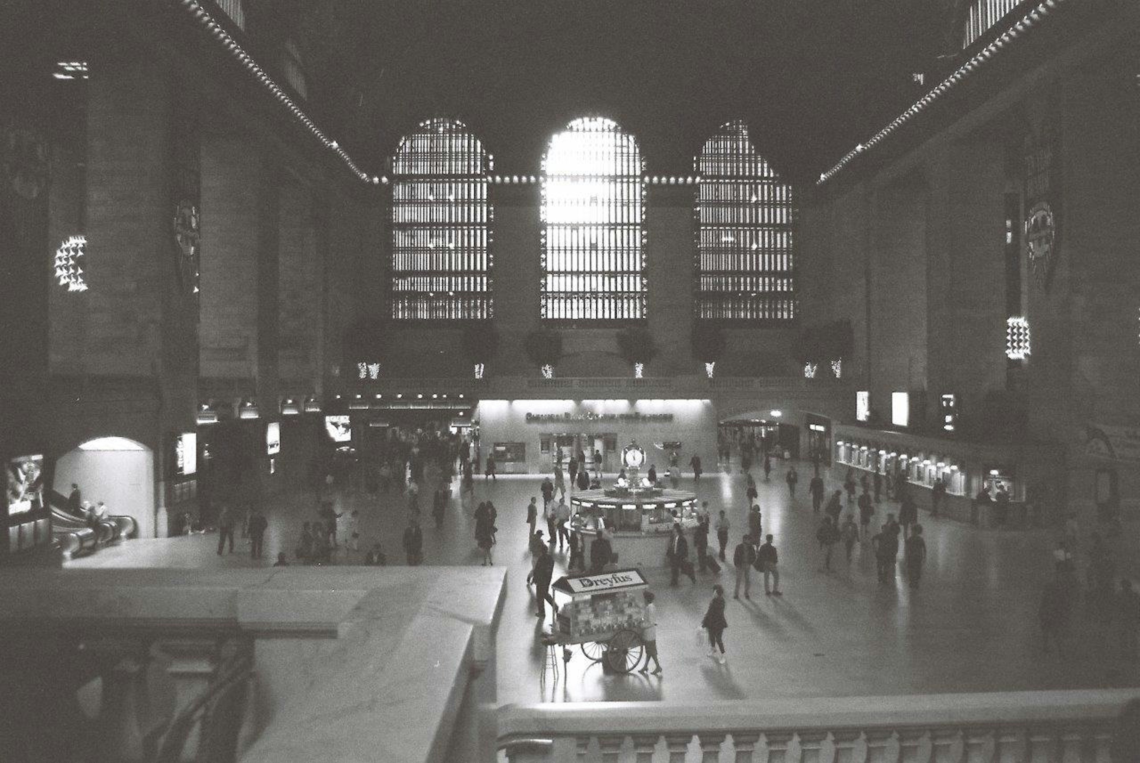 Interno della Grand Central Station in bianco e nero Persone che camminano nel vasto atrio Grandi finestre e bellissimo soffitto ad arco