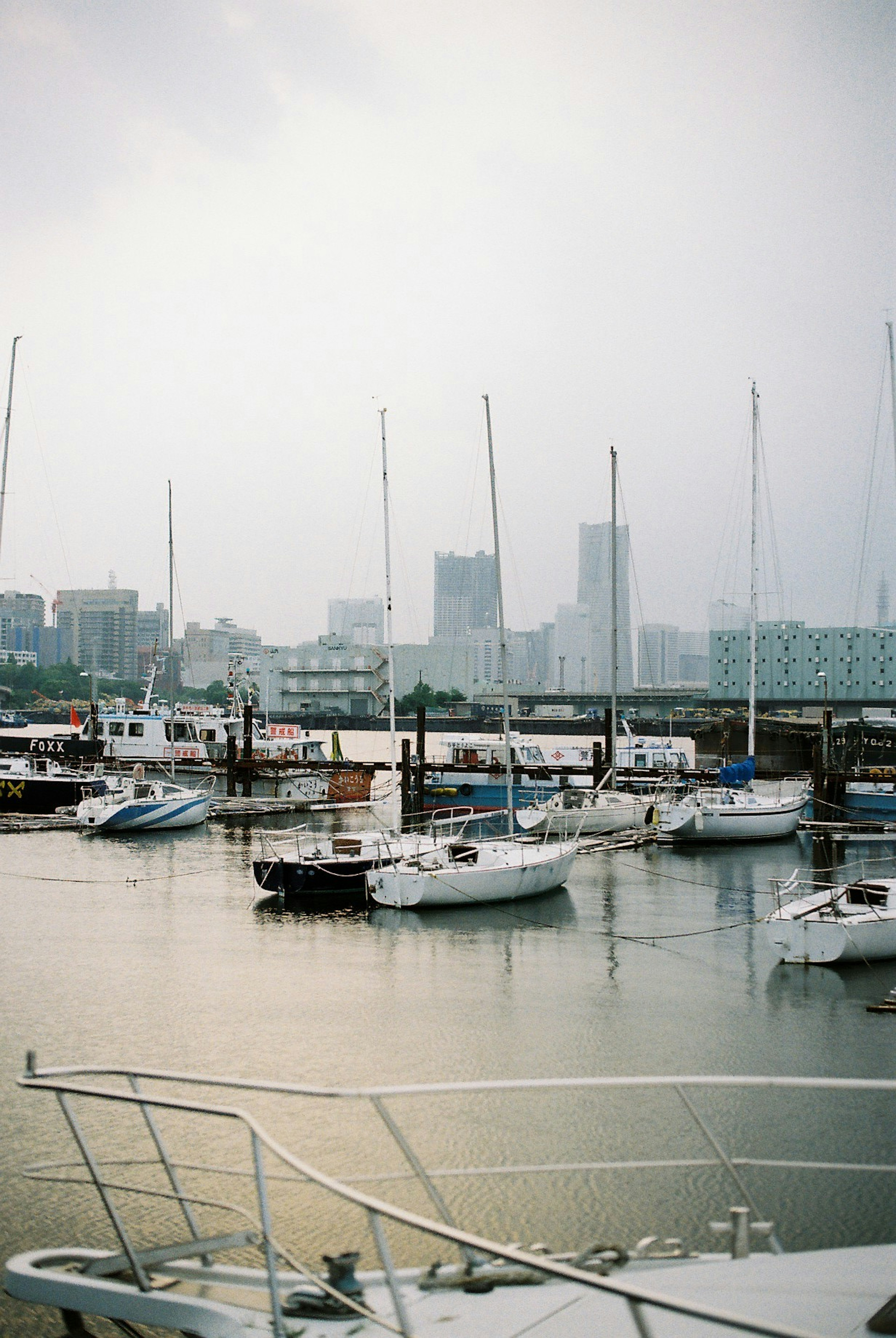 Ruhiges Wasser mit kleinen Yachten im Hafen und der Skyline der Stadt im Hintergrund