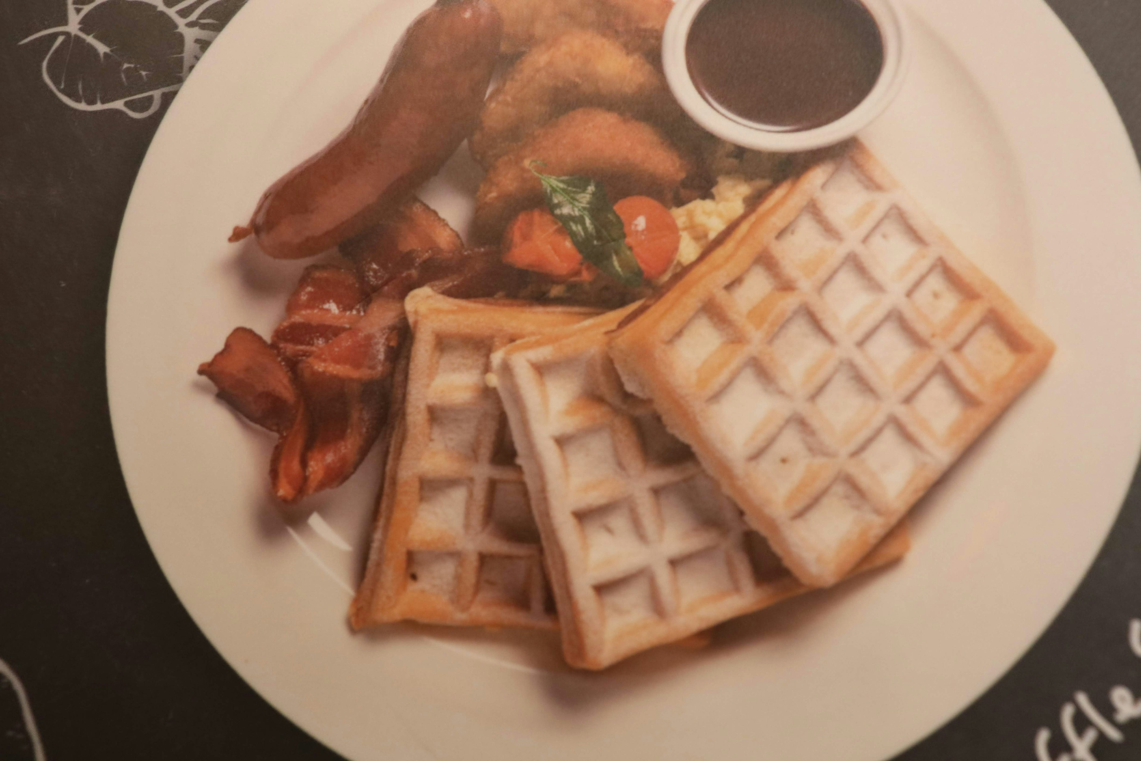 Plato de waffles con pollo frito tocino y jarabe de arce