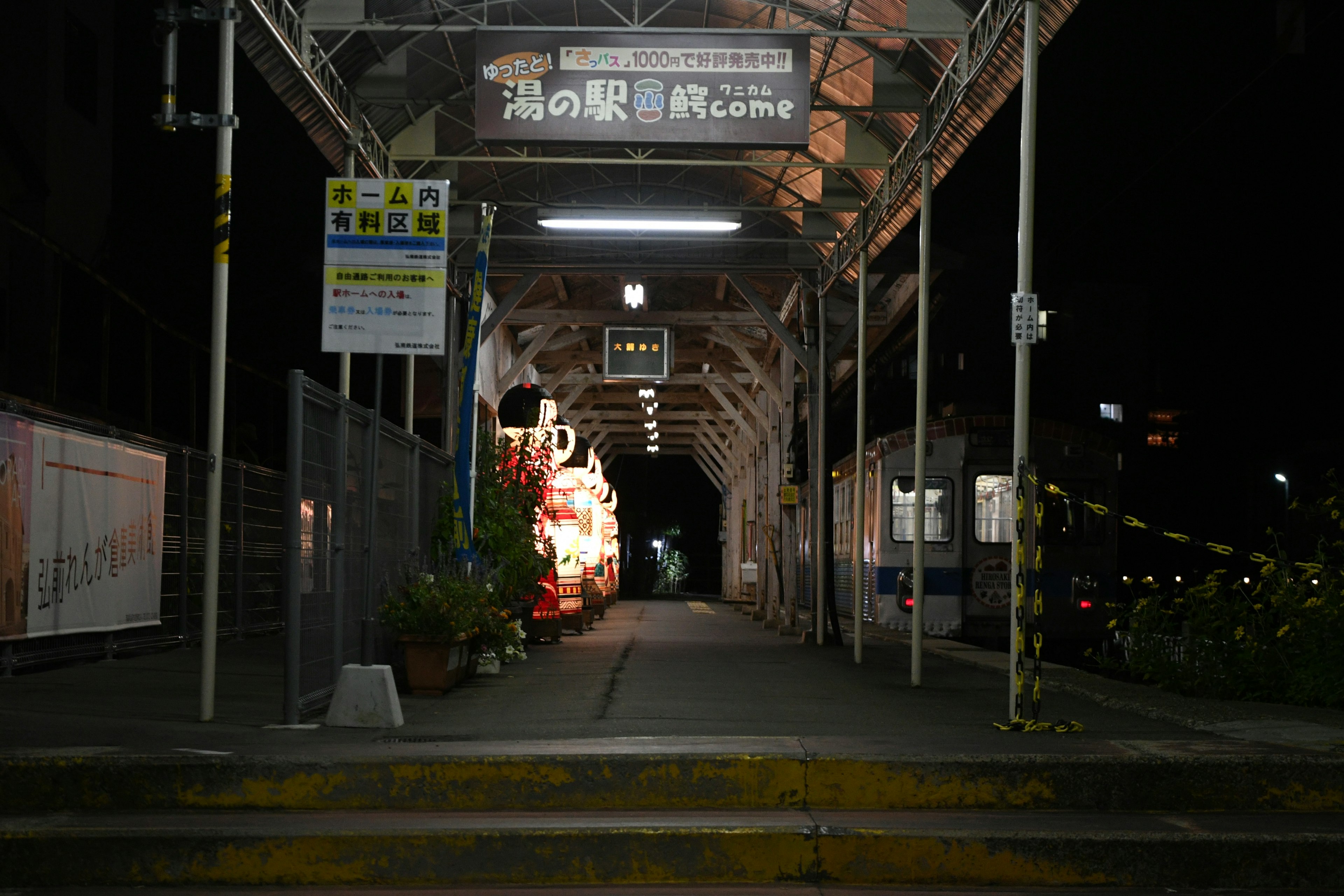 夜の駅の構内にある照明と植物