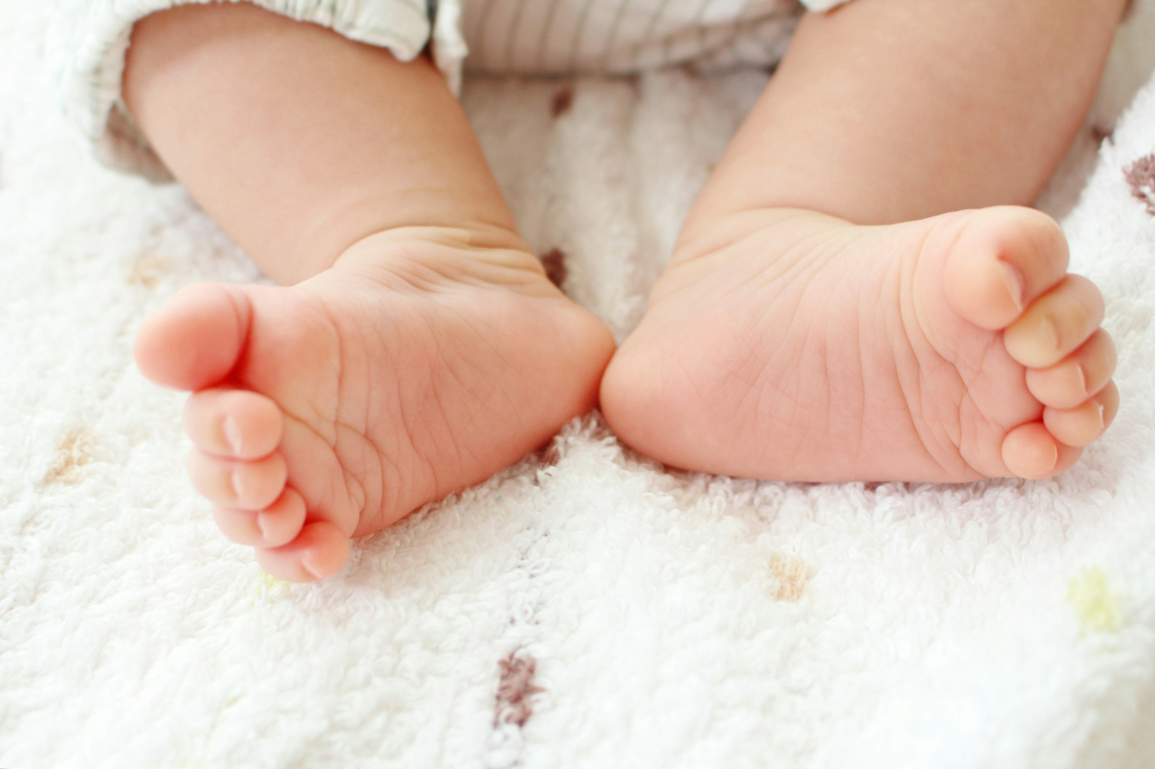 Kaki bayi beristirahat di atas handuk lembut