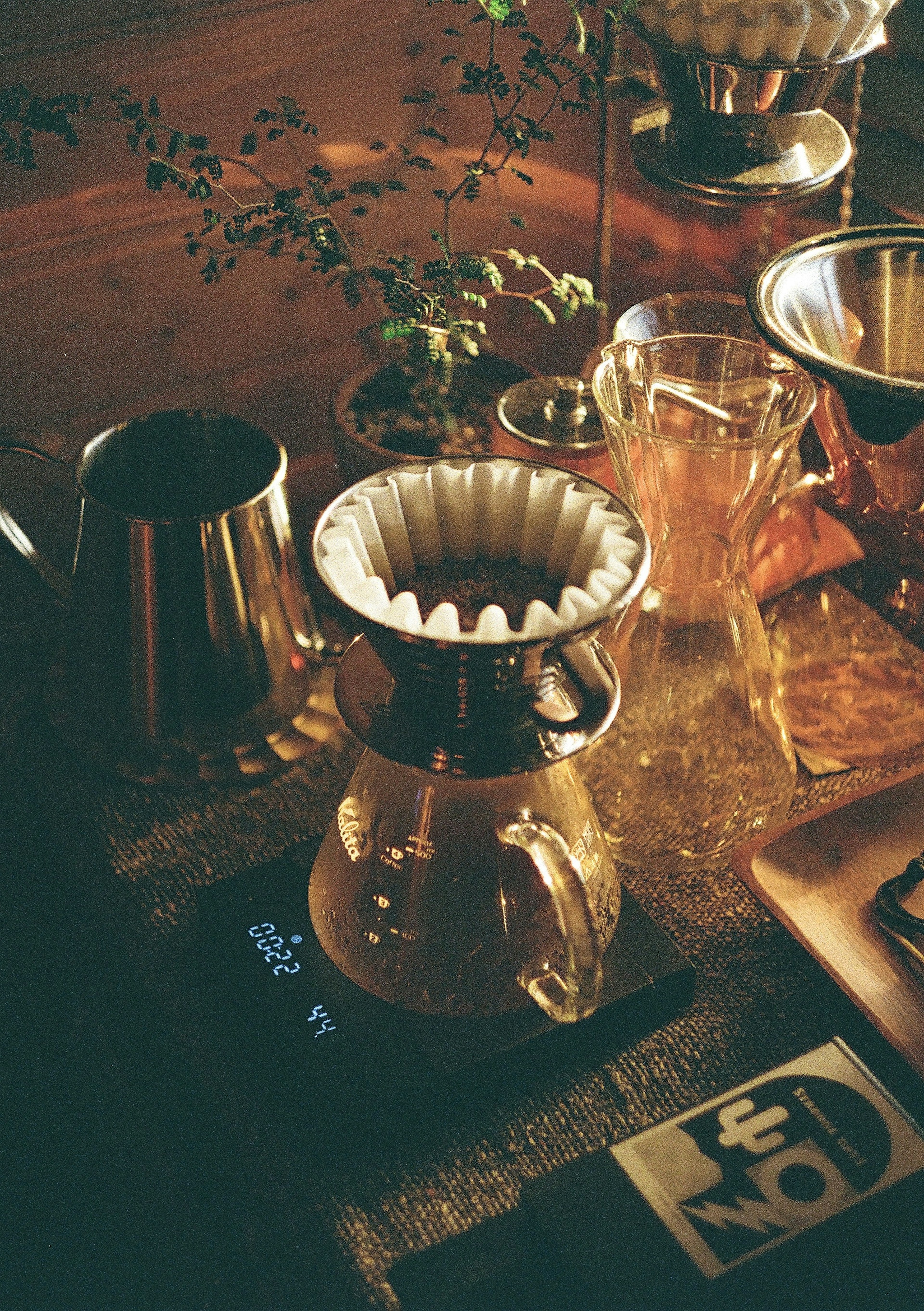 A beautiful coffee brewing setup featuring a dripper and various tools in warm lighting