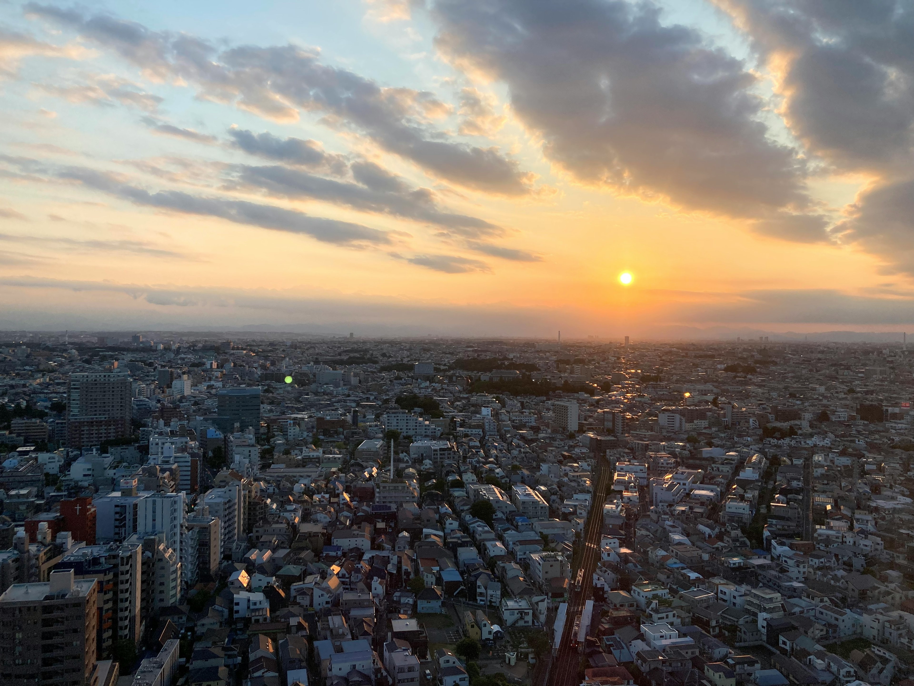 Panoramic view of a city at sunset with high-rise buildings and clouds in the sky