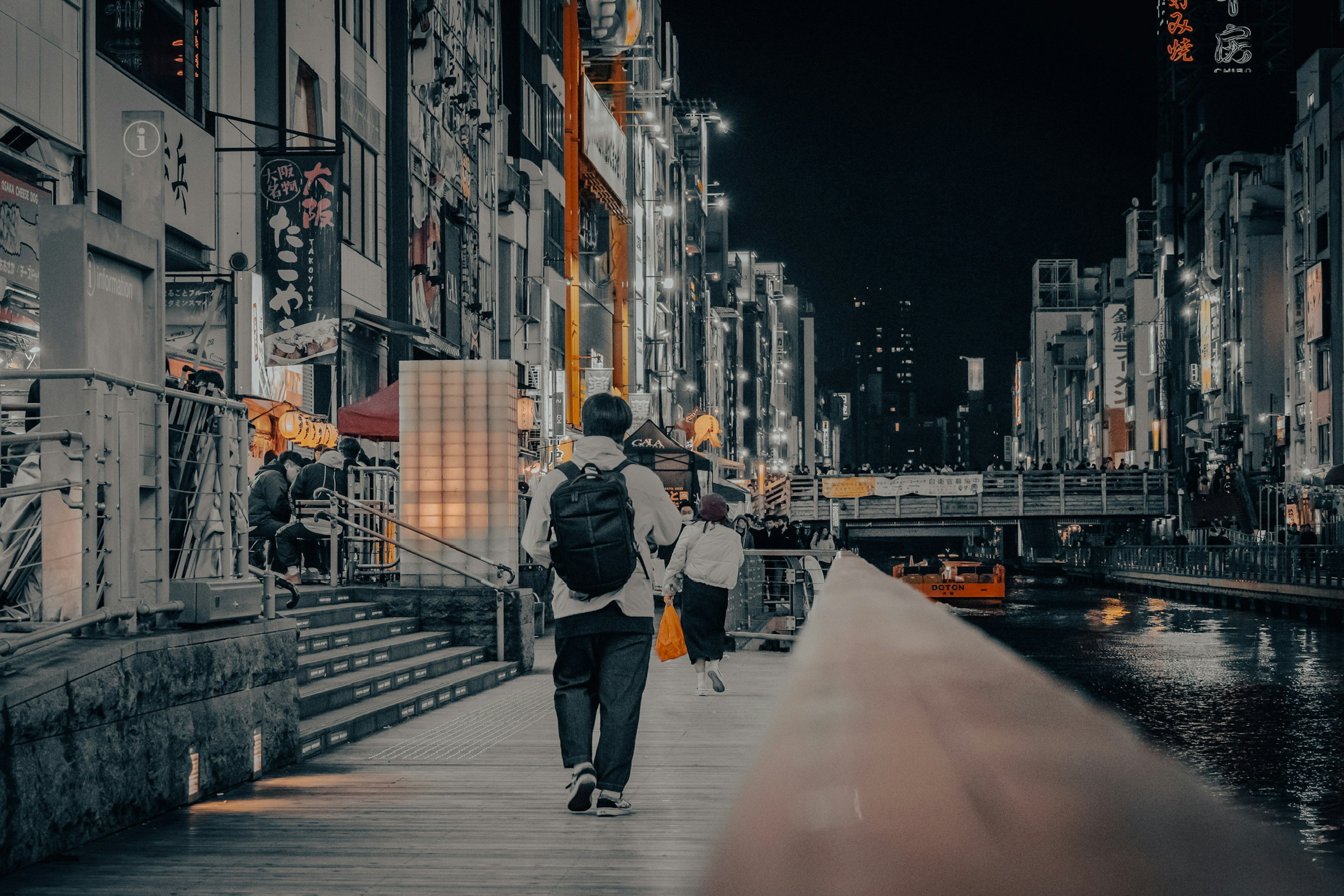 夜の街を歩く人と川の景色