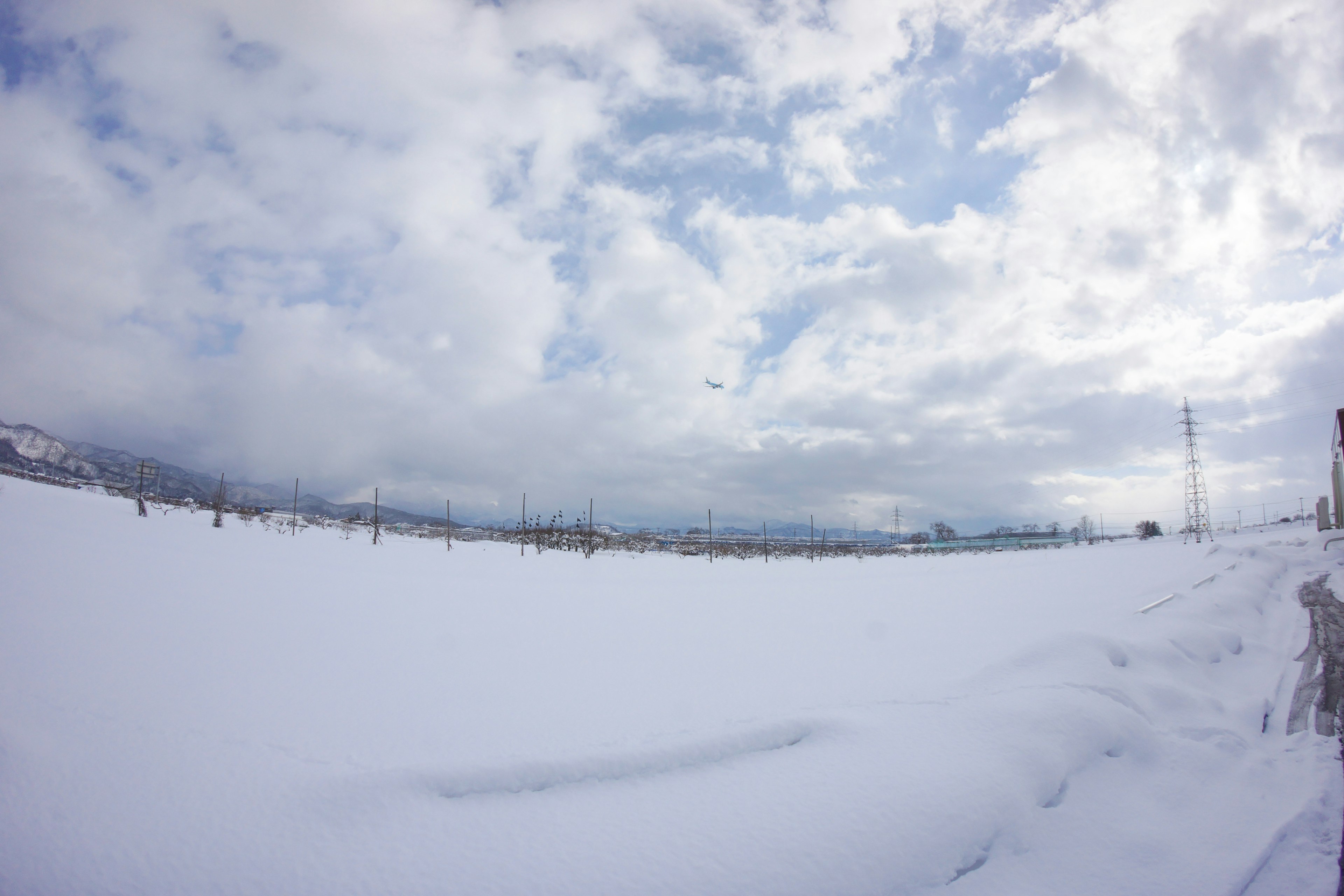 Ampio paesaggio innevato con cielo nuvoloso