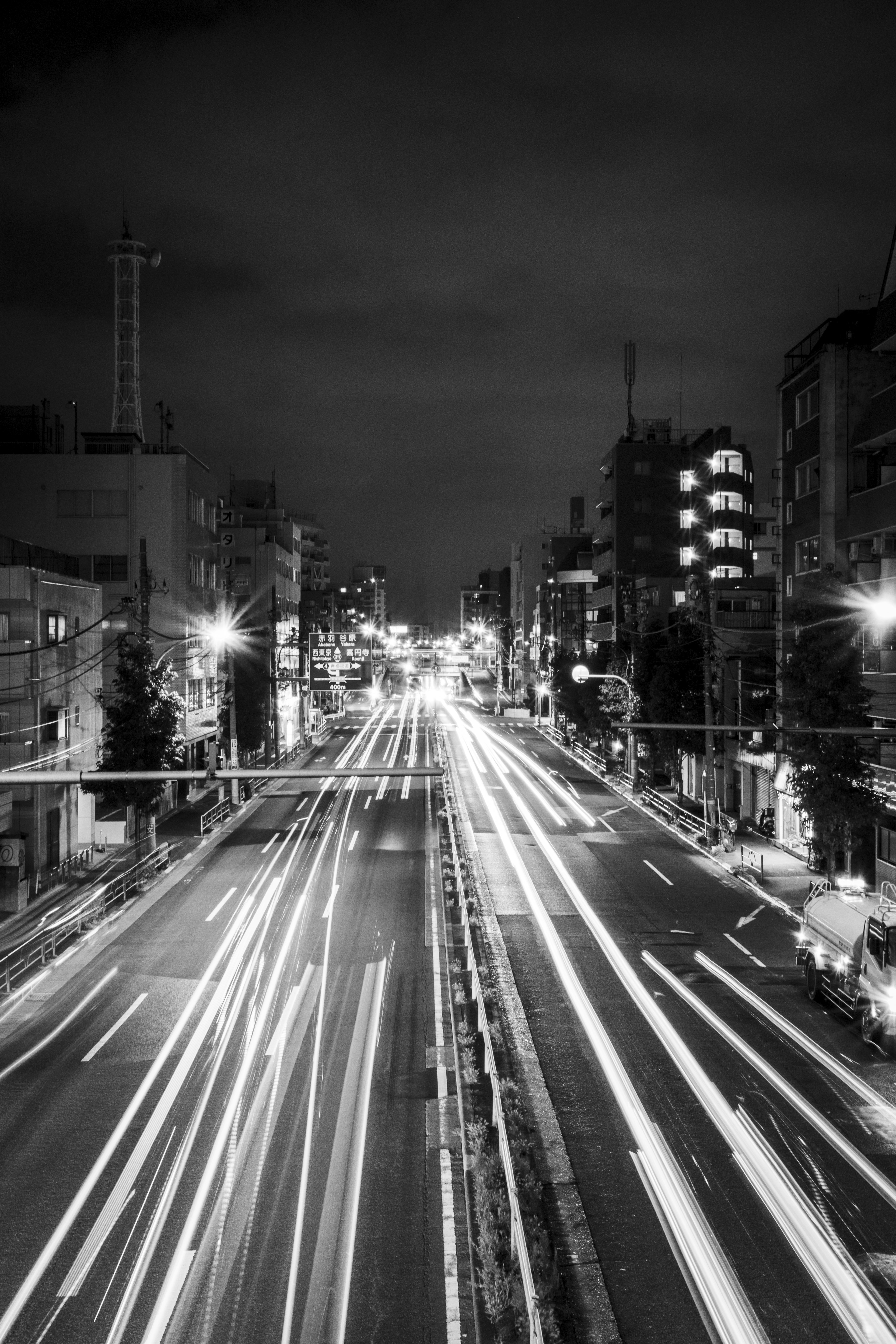 Paesaggio urbano notturno in bianco e nero con luci del traffico