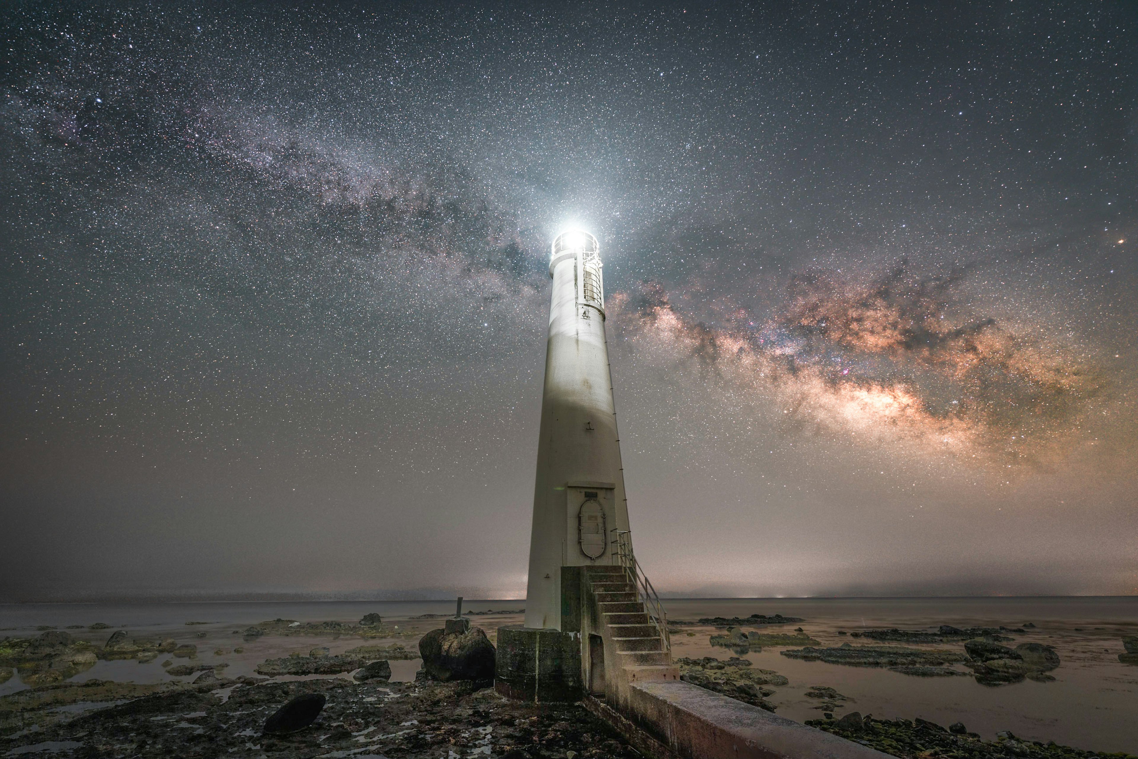 Faro bajo un cielo estrellado con una hermosa Vía Láctea