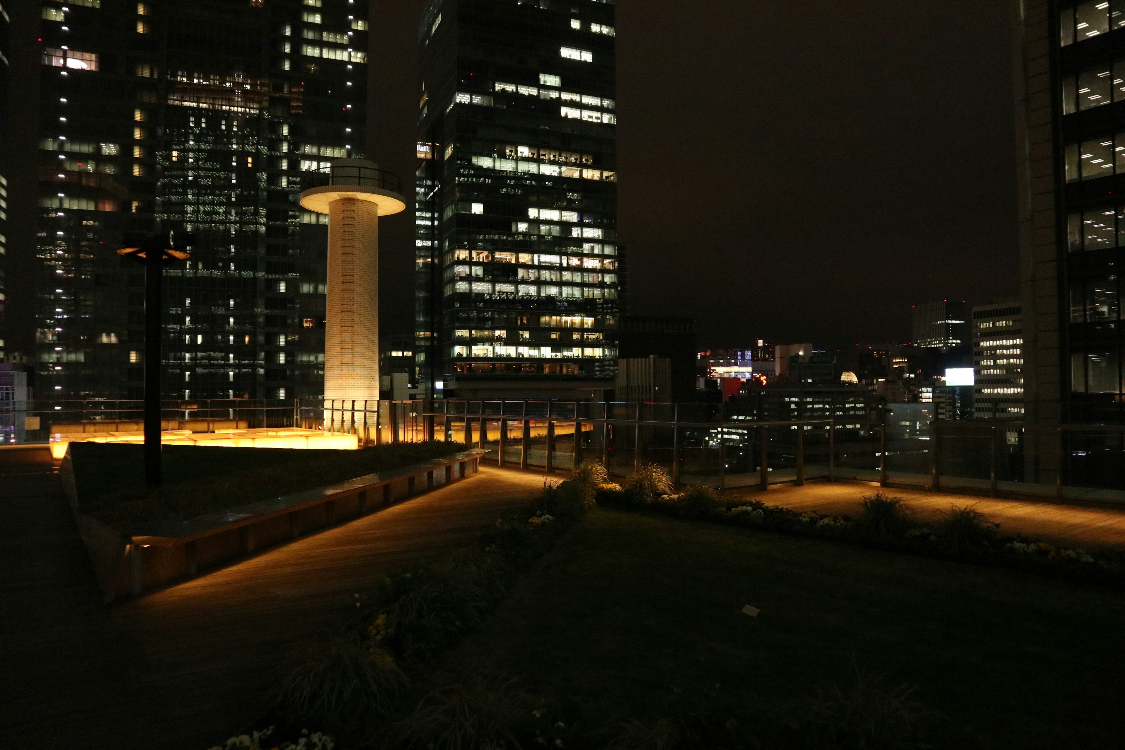 Paisaje urbano nocturno con caminos iluminados y edificios altos