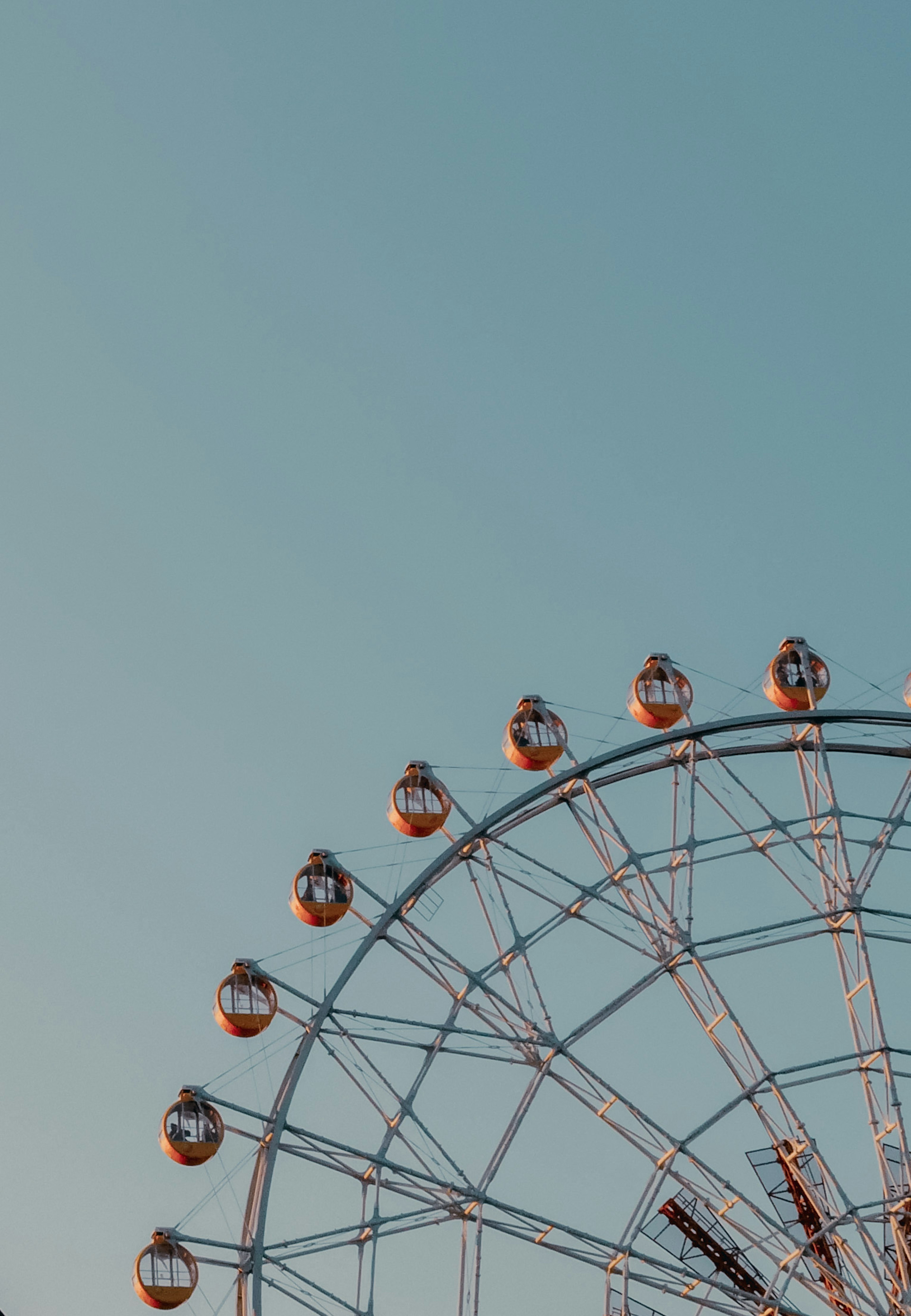 Gambar roda ferris di latar belakang langit biru cerah