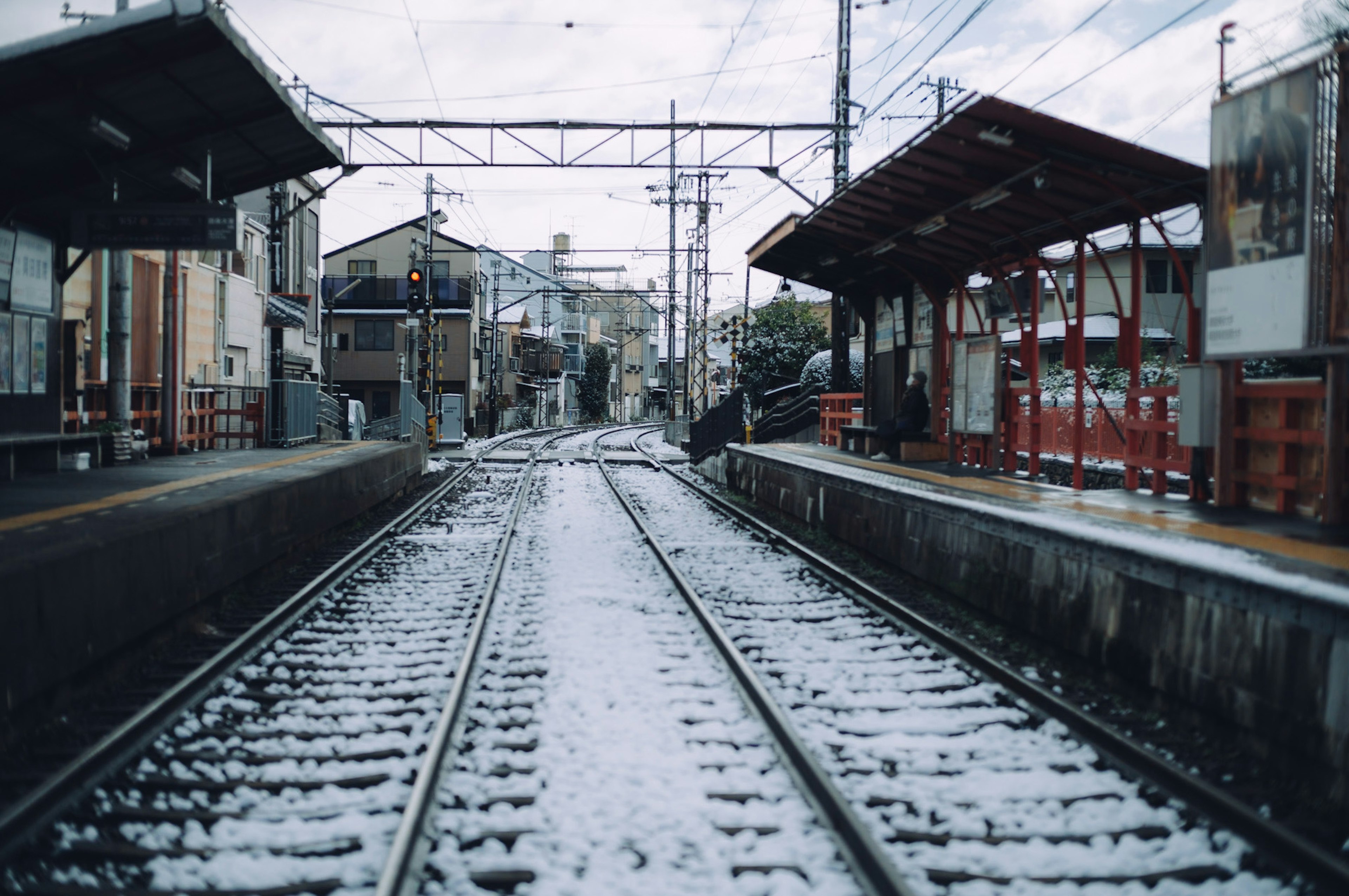 Voie ferrée enneigée et bâtiments de gare