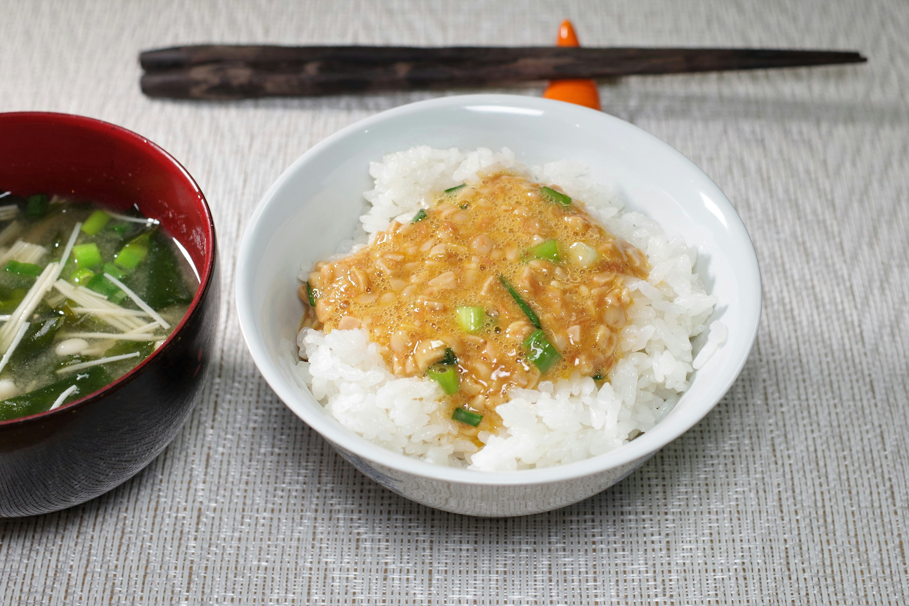 Bowl of rice topped with sauce and a side of miso soup