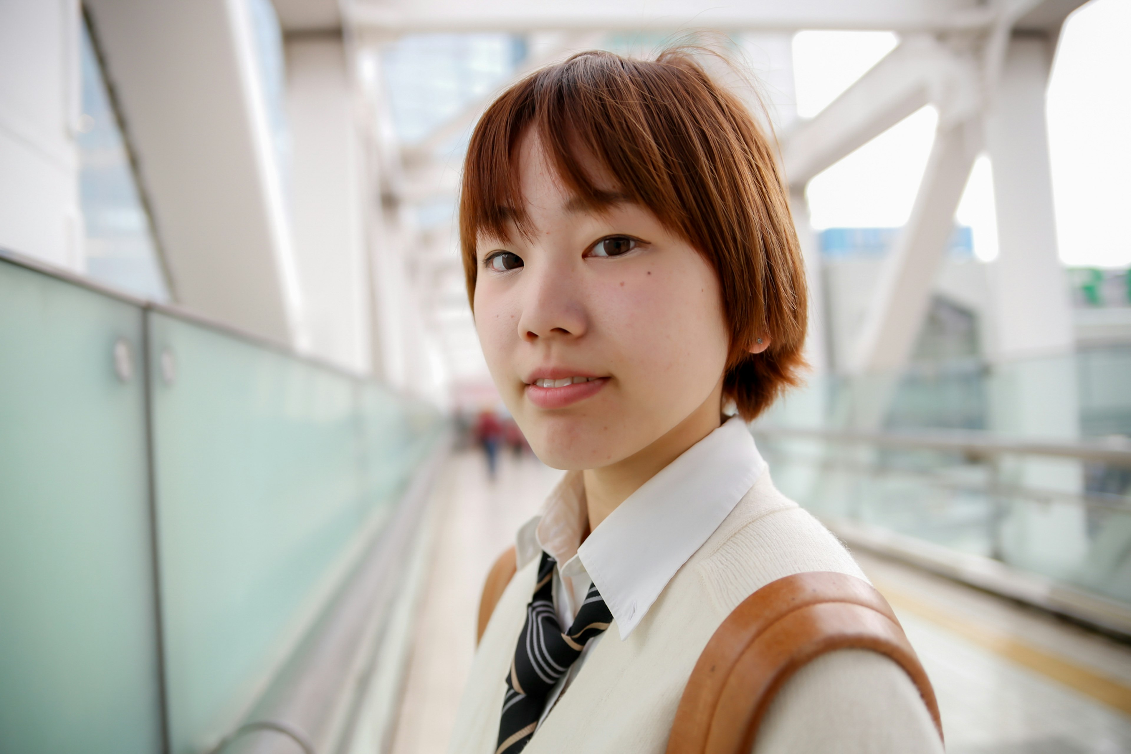 Young woman wearing a white sweater and tie smiling