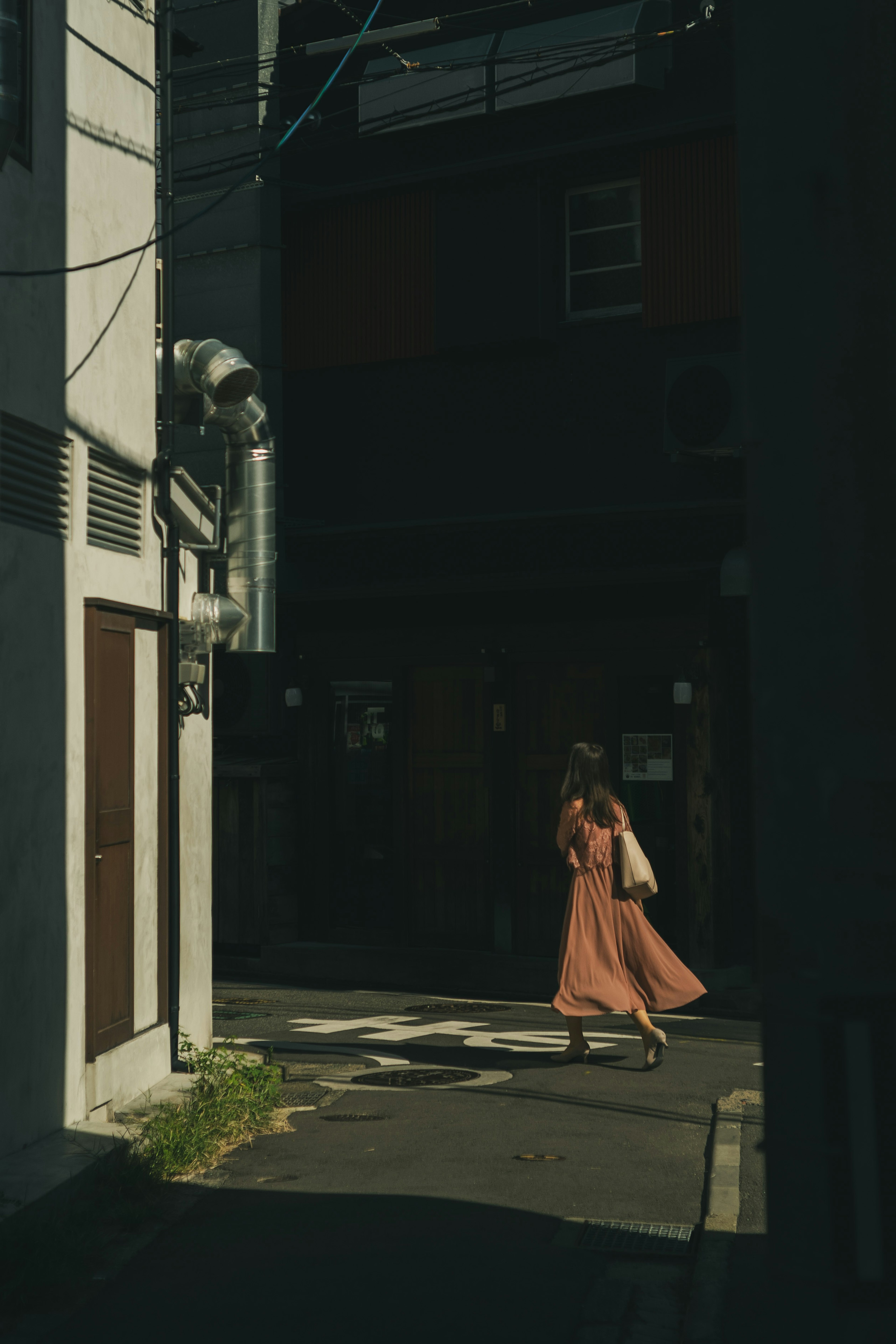 薄暗い路地を歩く女性の姿