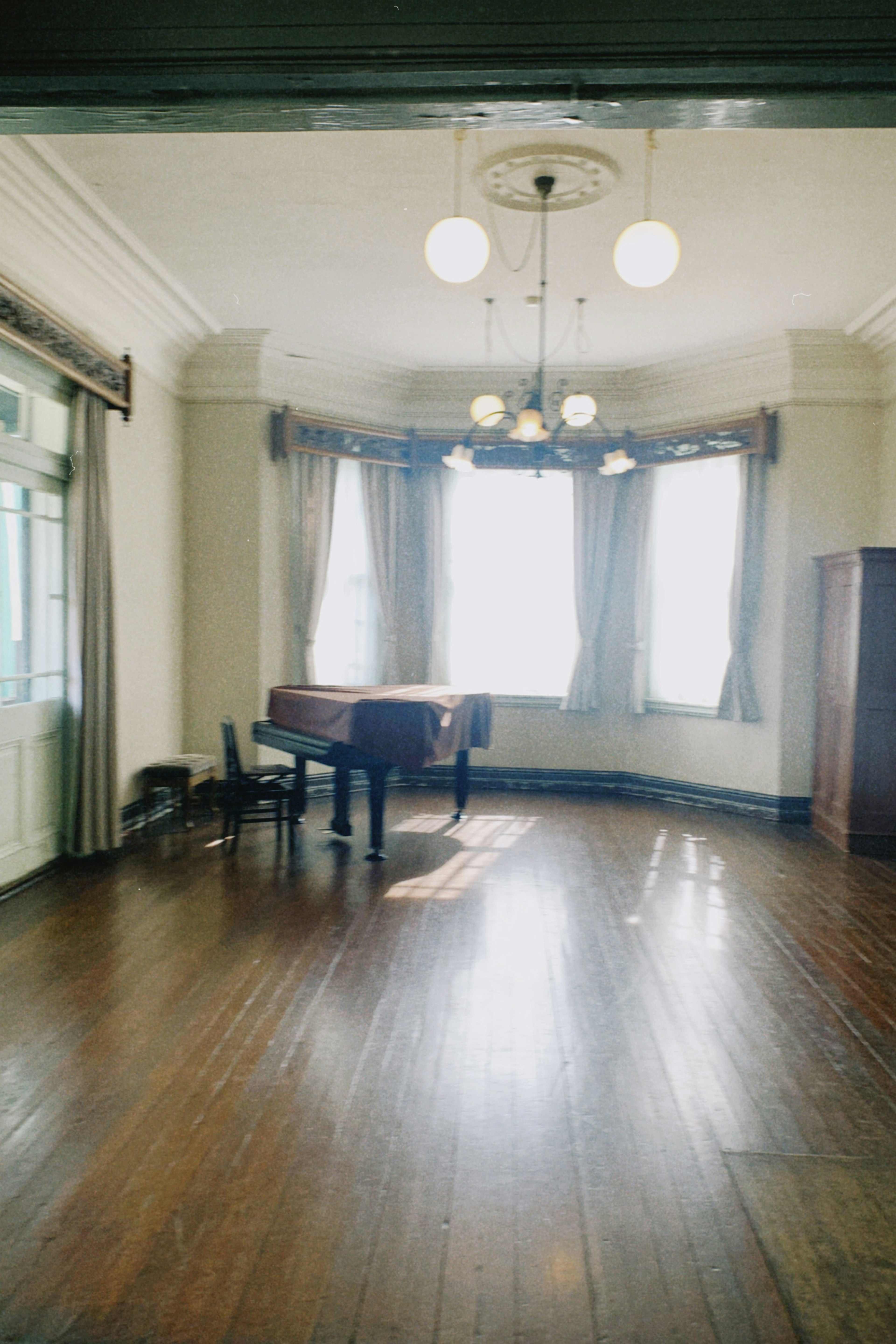 Habitación espaciosa con grandes ventanas y un piano de cola