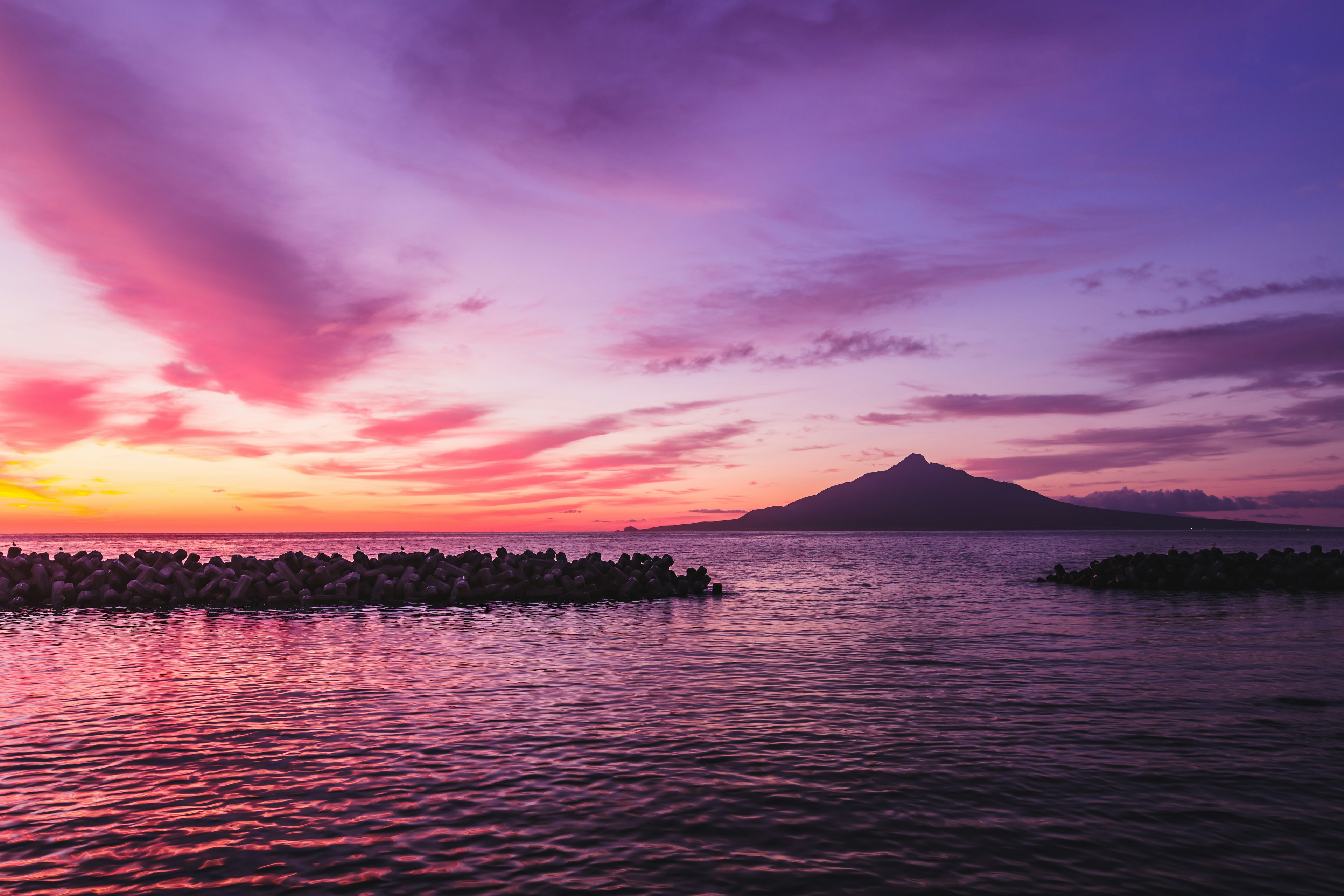 Beautiful sunset over calm sea with a mountain in the distance