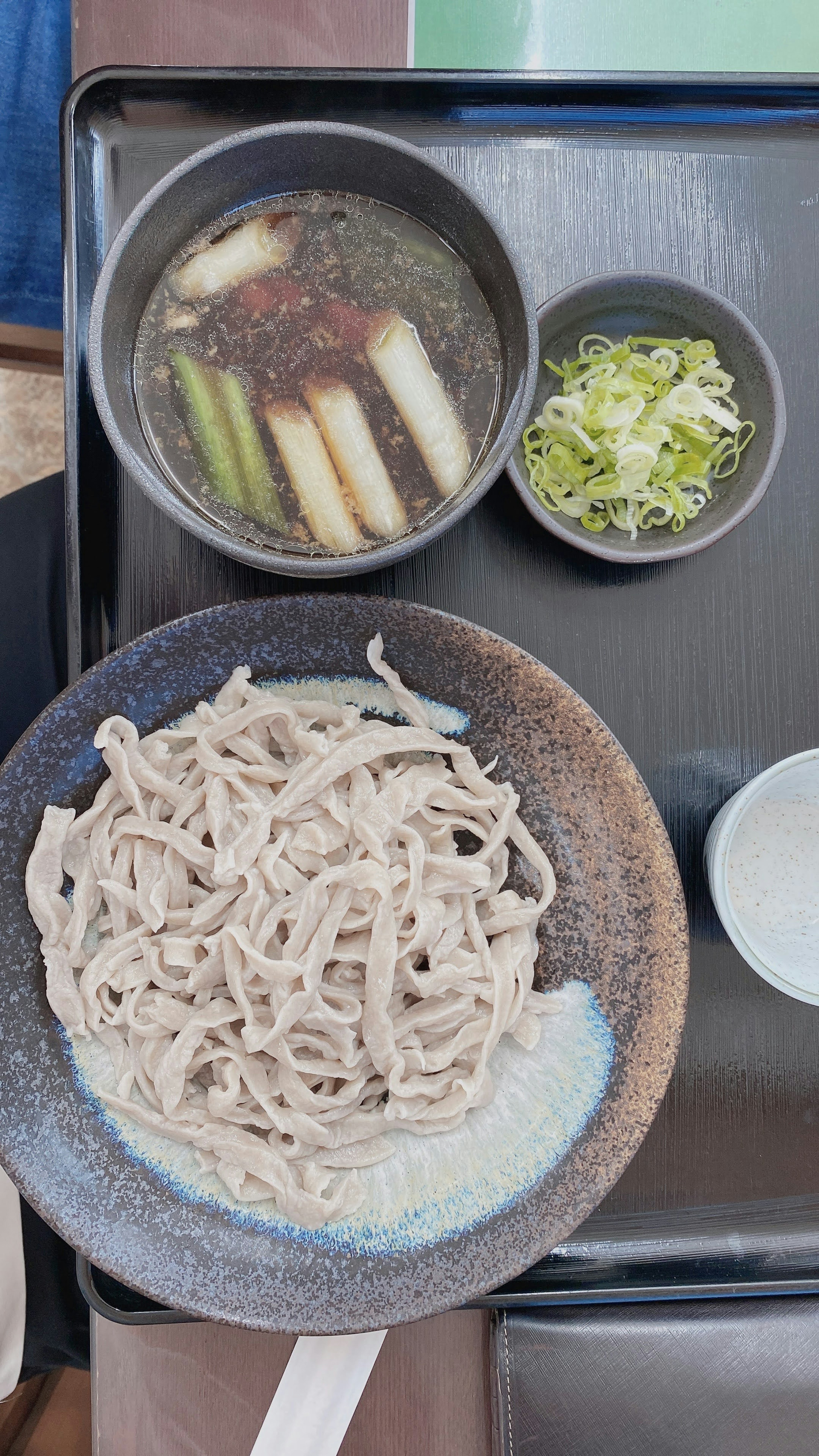 Un plato de soba bellamente presentado con salsa para mojar