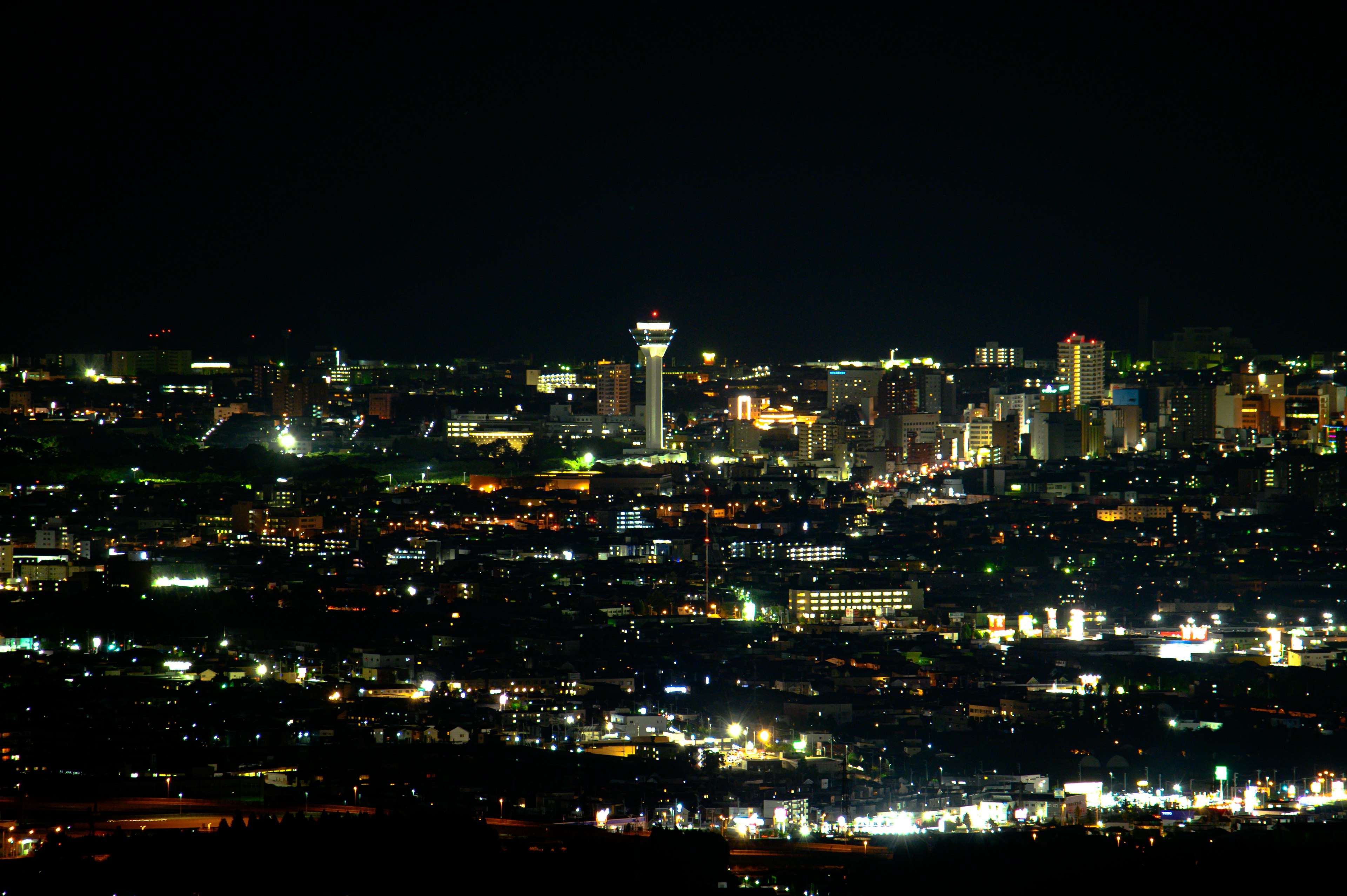 Nighttime cityscape view featuring illuminated skyscrapers