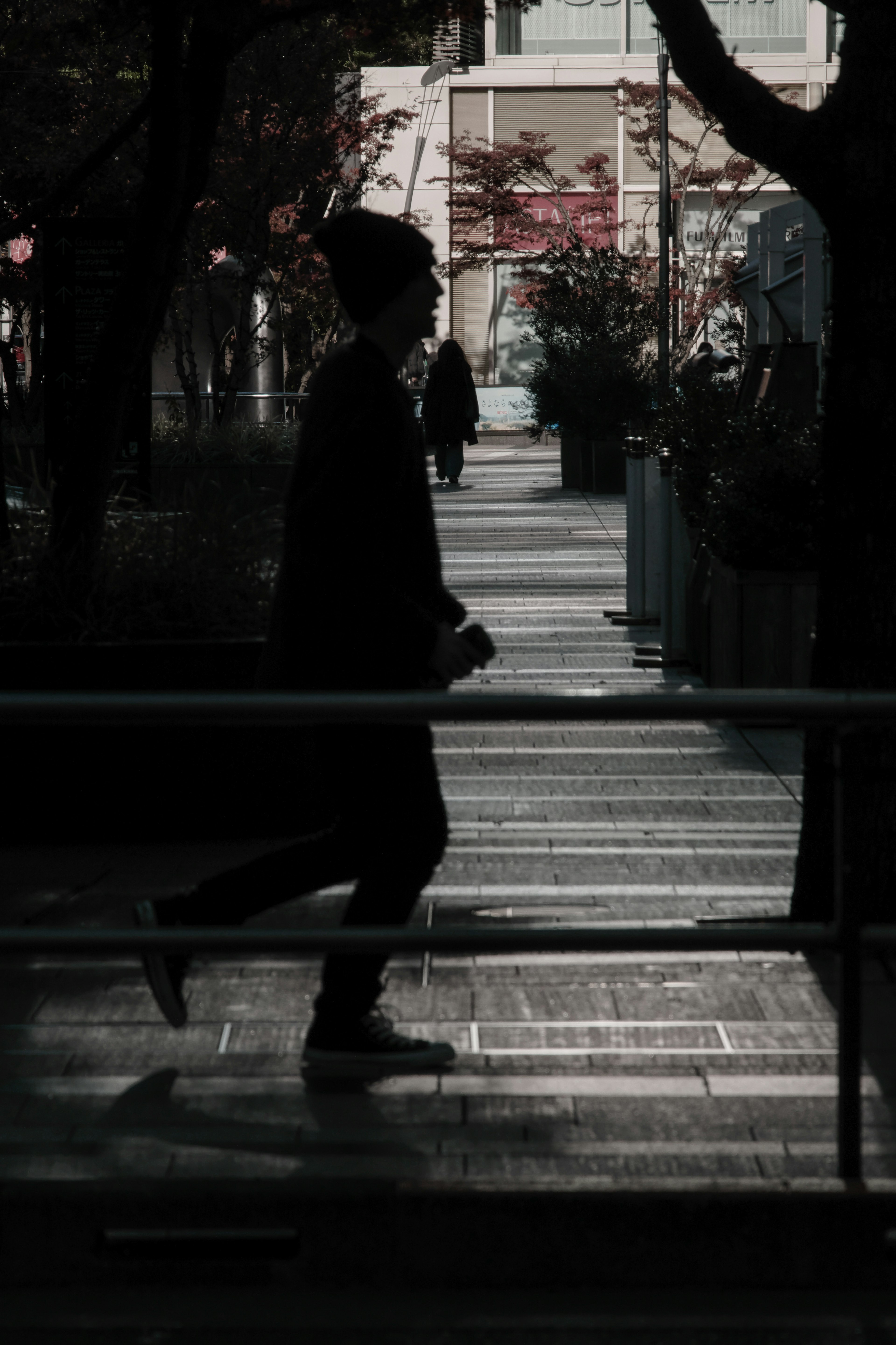 人のシルエットが歩いている都市の通りの風景