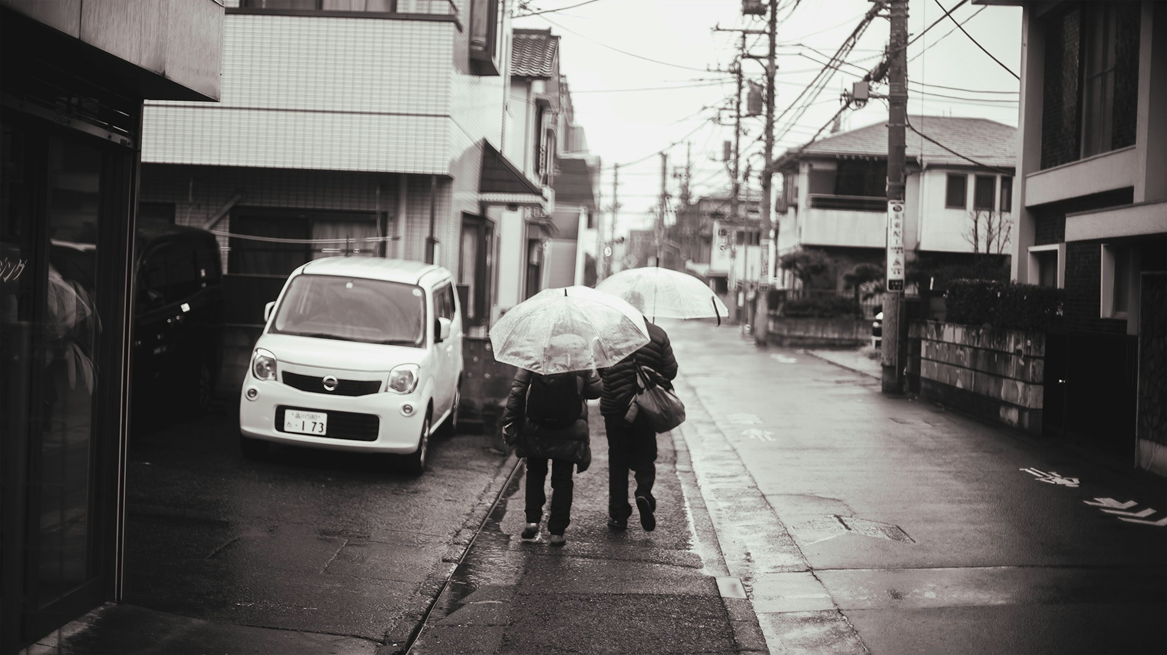 สองคนเดินอยู่ใต้ร่มในสายฝนกับทิวทัศน์ในเมือง