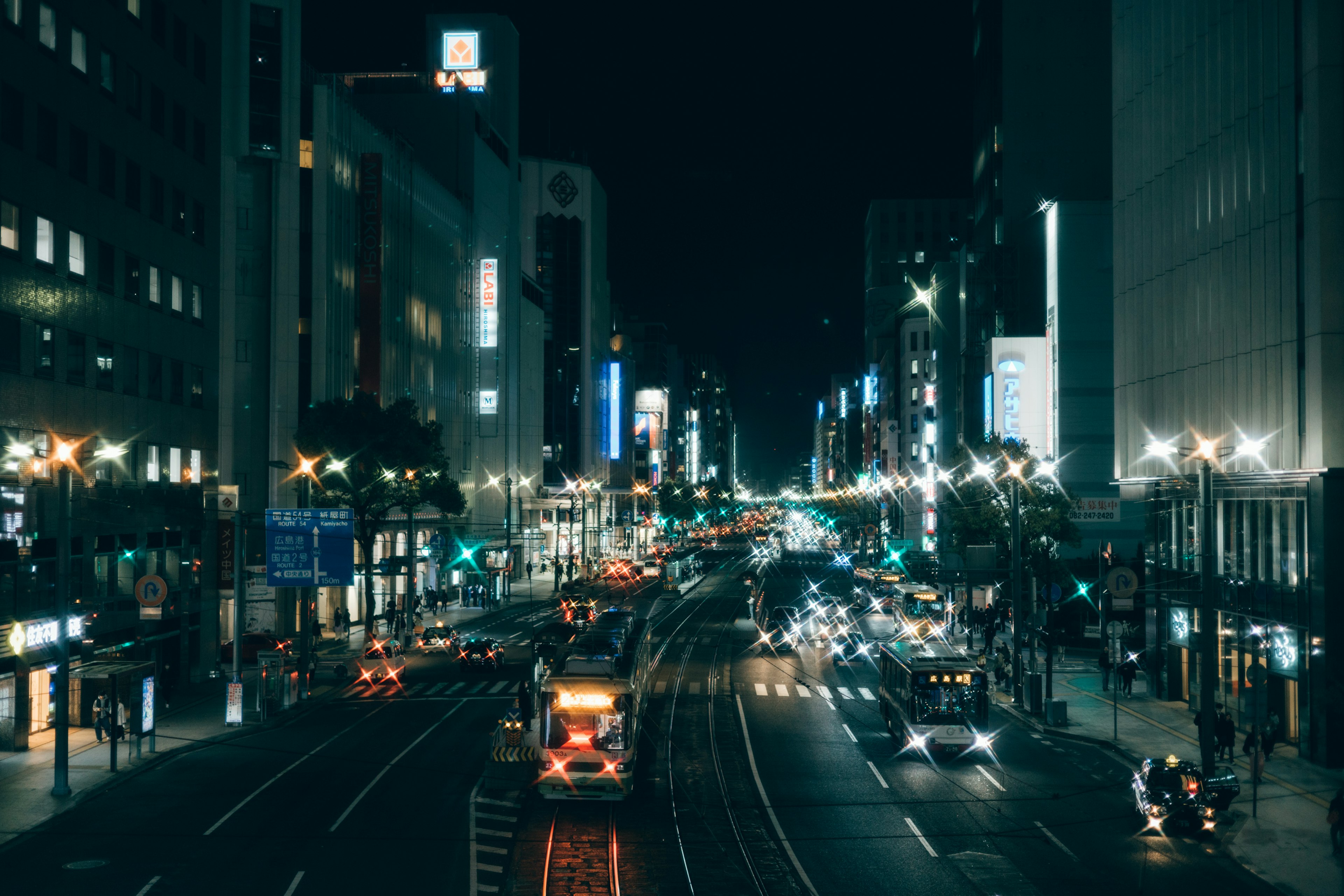 夜间城市街道，车辆和霓虹灯标志