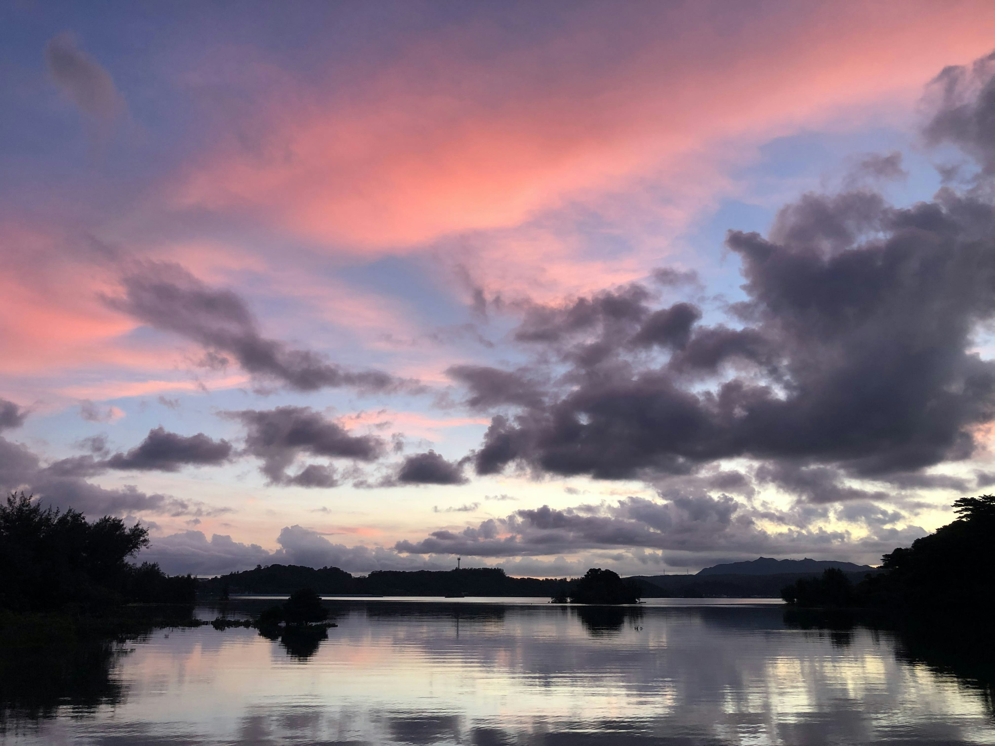 Ciel de coucher de soleil et nuages reflétés sur un lac calme