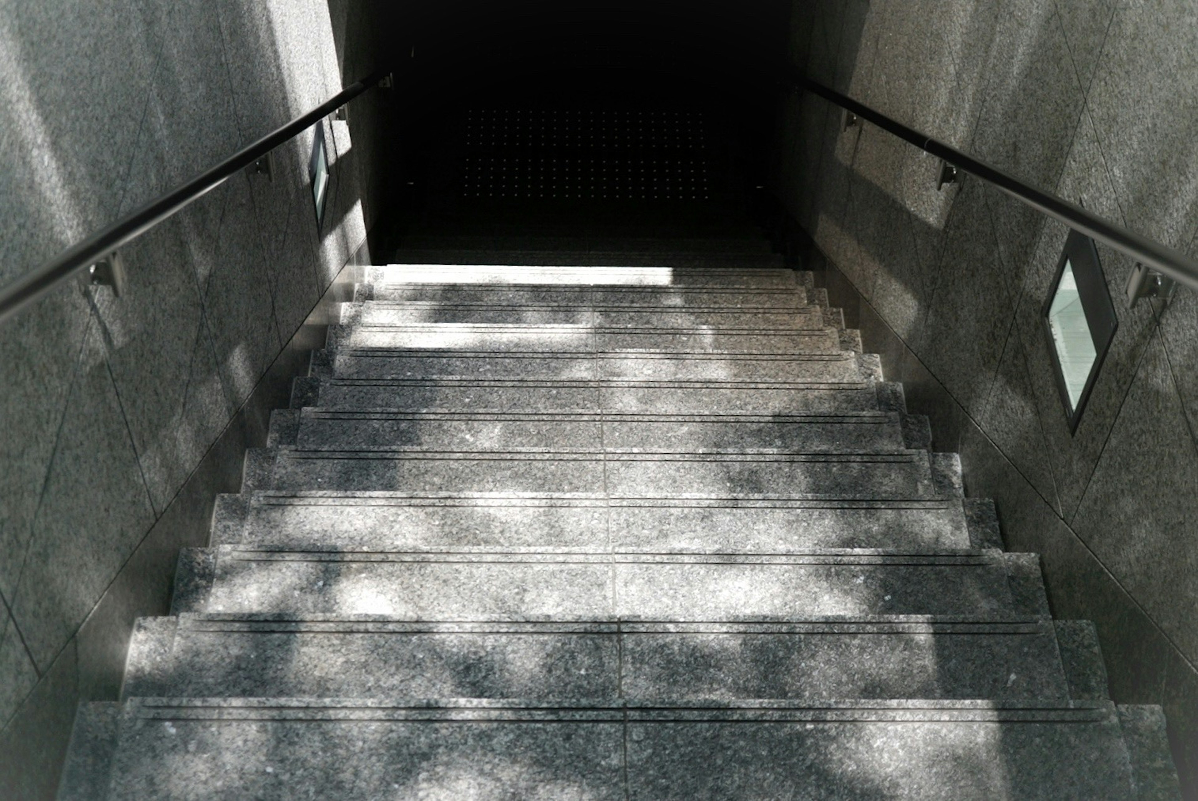 Vue du bas des escaliers en pierre avec des ombres projetées