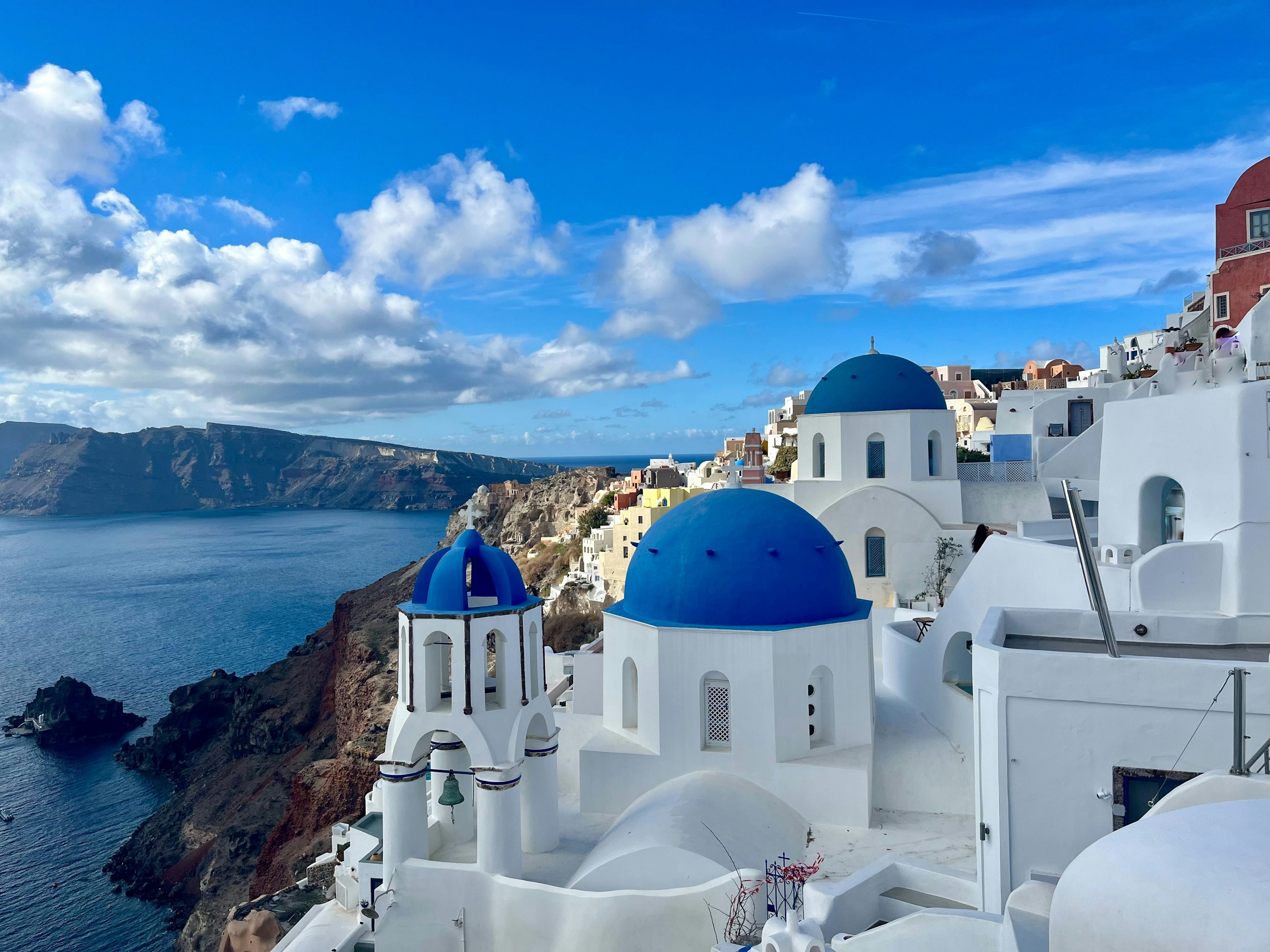 White buildings with blue domes overlooking the sea