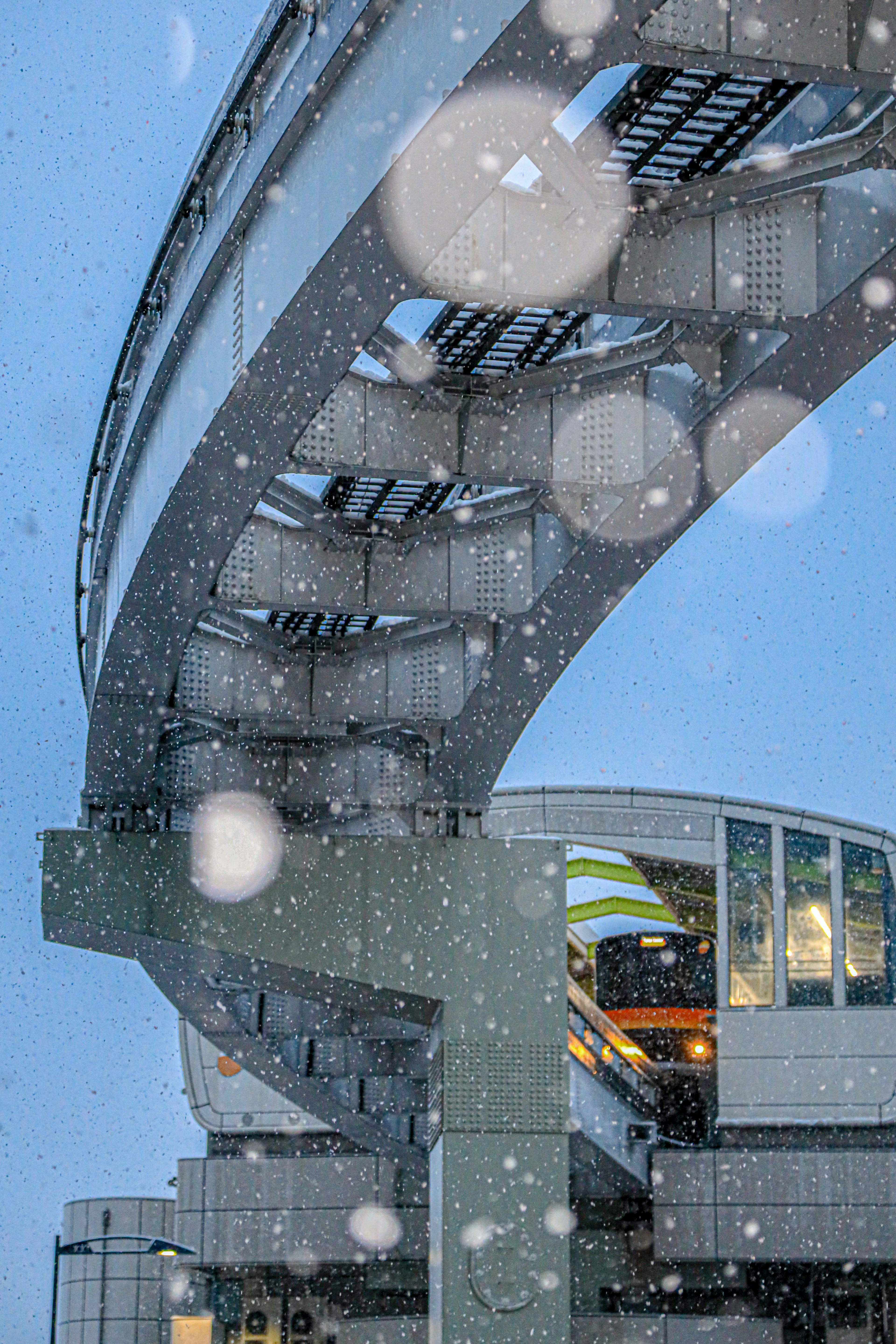 Bild zeigt die Struktur der Hochbahn und eine Station, die teilweise vom fallenden Schnee verdeckt ist